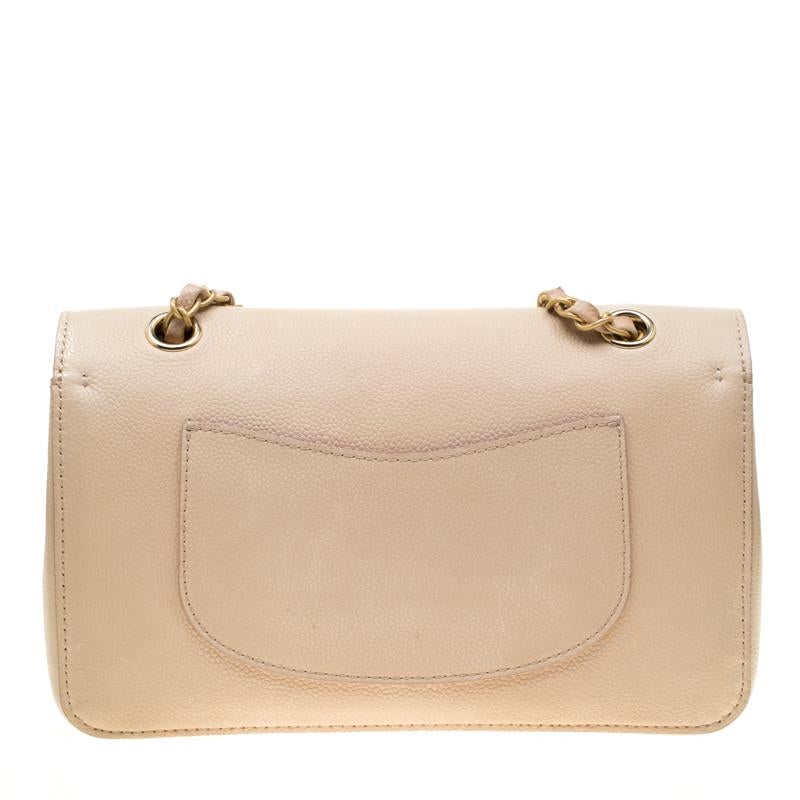Crafted with precision from caviar leather, and touched with an understated beige shade, this Classic Pure Double Flap bag from Chanel cannot get any luxurious than it already is! As is the design with almost all their flap bags, this bag brings the
