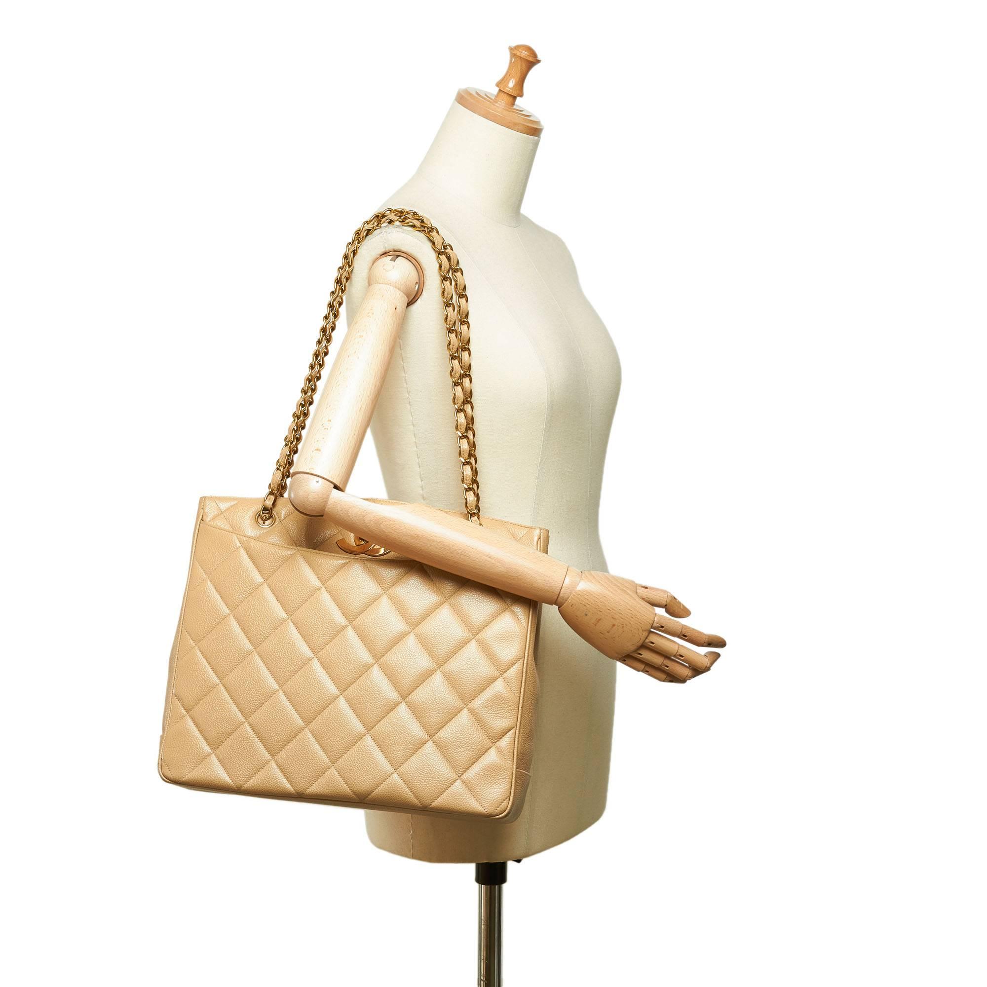 - Vintage 90s Chanel beige caviar leather shoulder bag. 

- Featuring an exterior front and back open pocket, gold-tone chains, gold-toned 