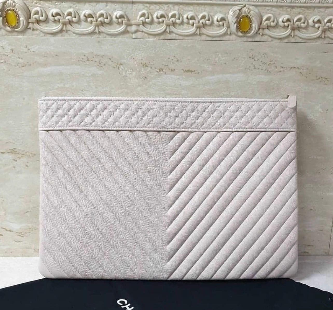 This fabulous Chanel Beige Clair Chevron Quilted Caviar Leather CC Large O-Case Zip Pouch is the most chic way to carry your prized technology.
It features durable quilted grained caviar leather with a lovely gold CC emblem on the front.
Secure your