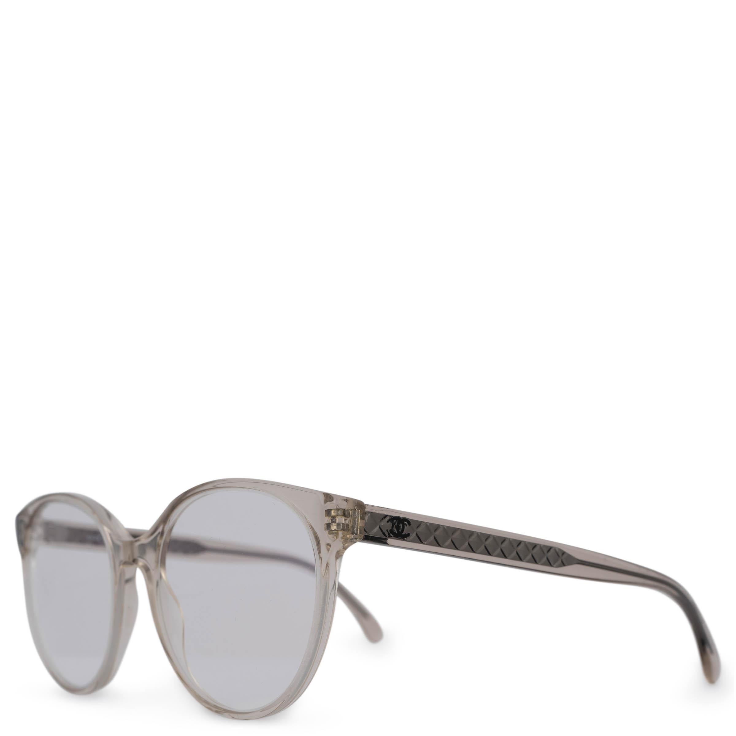 These 100% authentic Chanel round eyeglasses are crafted from transparent beige acetate and feature clear sample lenses. The design is accented with elegant quilting detail and the iconic CC logo on the temples, offering a subtle yet sophisticated