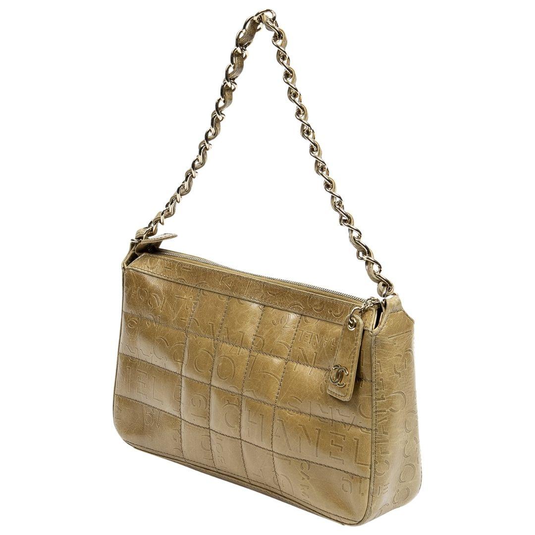 Rare 2002 Chanel Shoulder Bag crafted in beige quilted calfskin leather, silver-tone hardware, logo print throughout, and interwoven chainlink shoulder strap. The zippered closure opens to a stunning logo jacquard lining and one zippered pocket. The