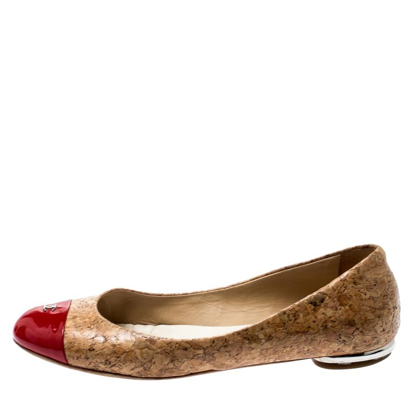 A common sight in the closets of fashionistas is a pair of Chanel ballet flats. They are perfect to wear on busy days and just stylish enough to assist one's style. These are crafted from beige cork and feature red patent leather CC cap toes and bow