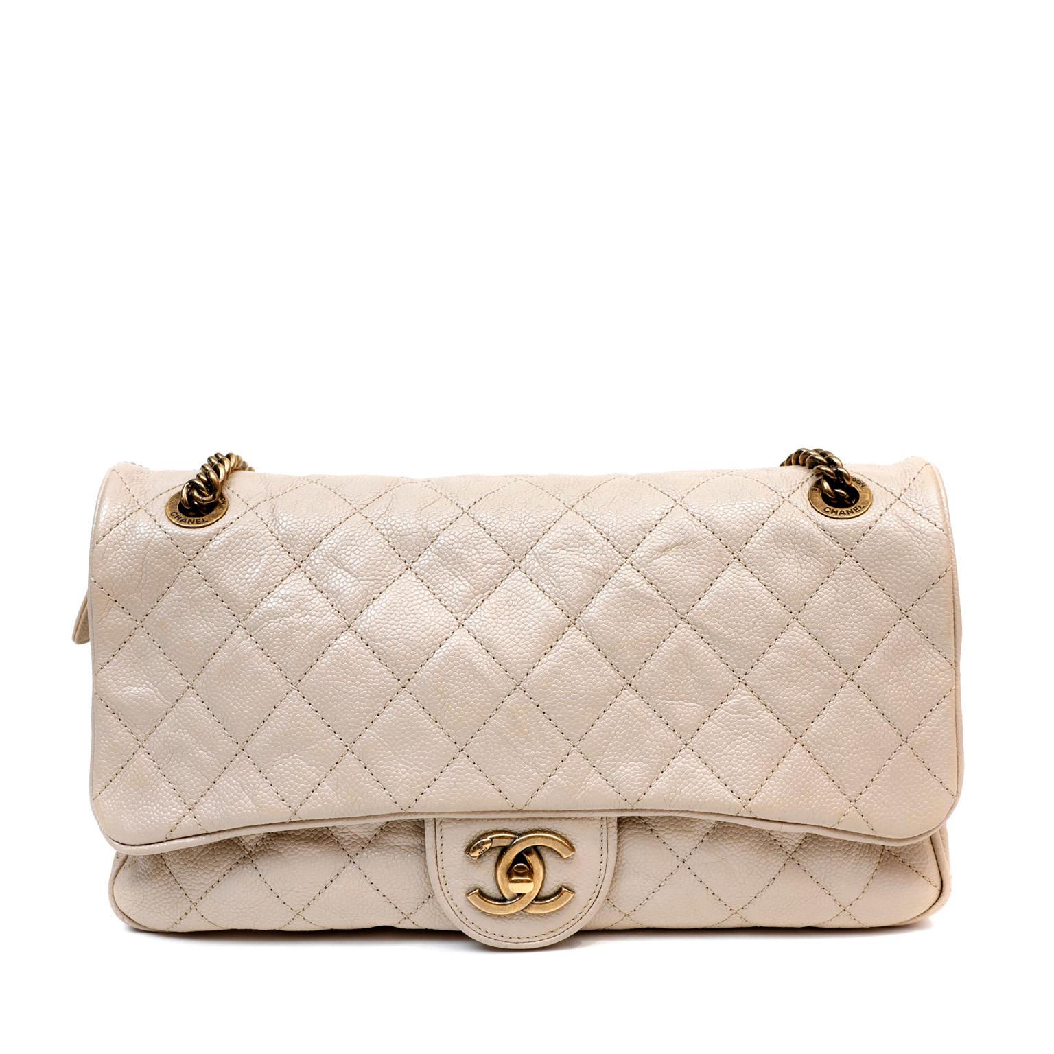 This authentic Chanel Beige Distressed Caviar Flap Bag is in good previously owned condition.  A somewhat more relaxed silhouette than the Classic Flap, this crumpled caviar version is perfect for nearly any occasion. Neutral beige caviar leather is