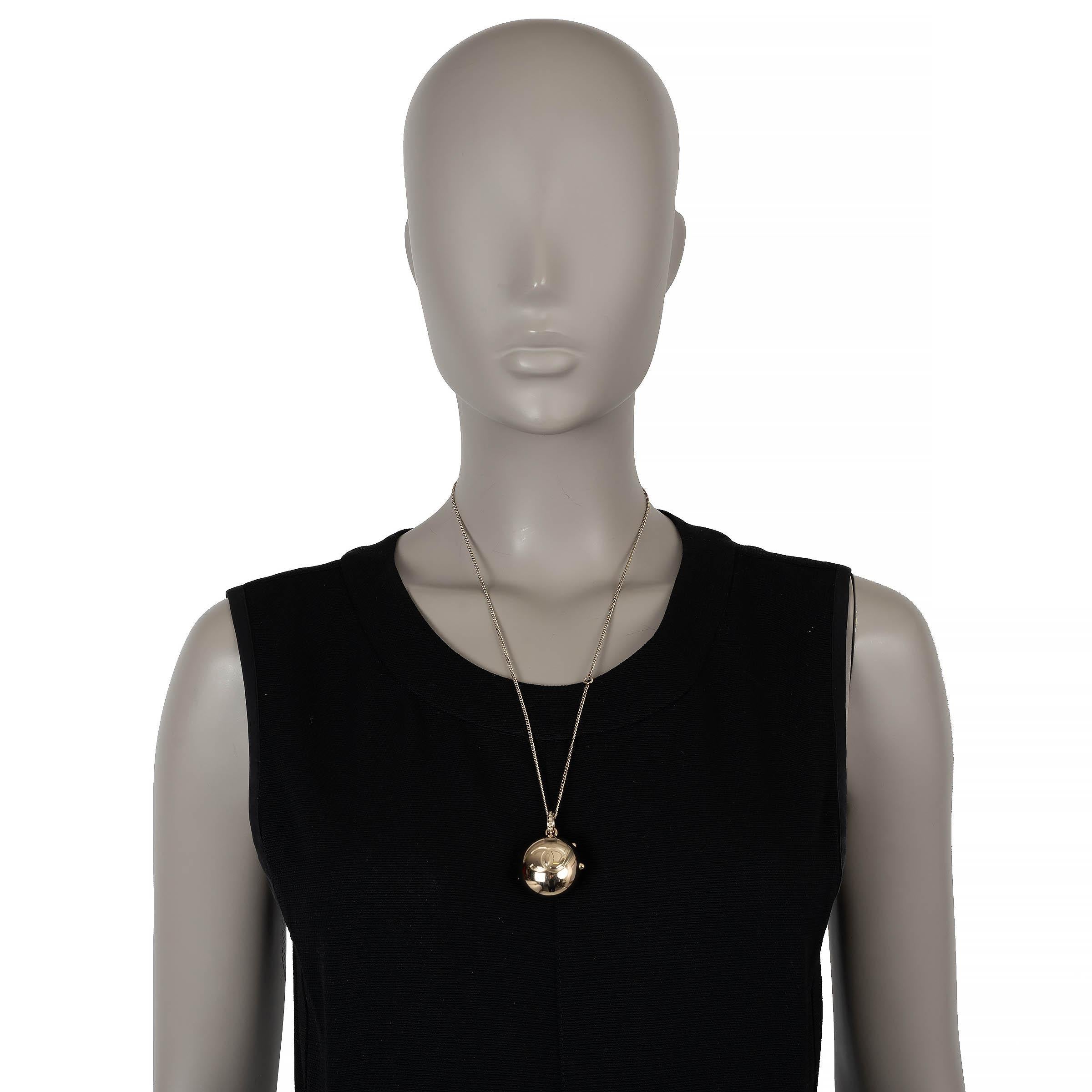 Ce collier en chaîne 100% authentique de Chanel en métal doré clair est un mélange intemporel d'élégance et de savoir-faire. Doté d'un pendentif en forme de sphère, il est délicatement gravé de l'emblématique CC d'un côté et de la signature de