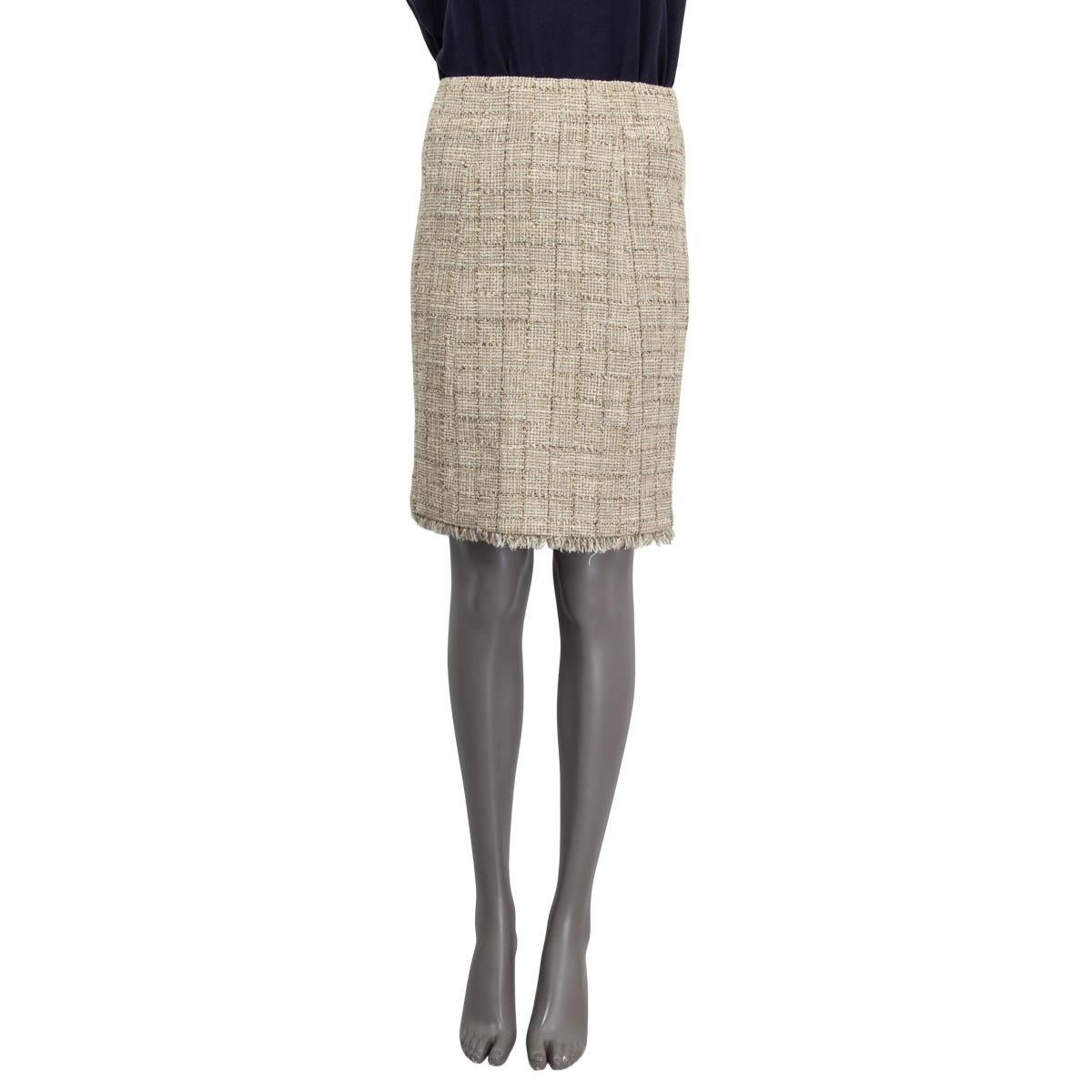 100% authentic Chanel tweed skirt in beige, ecru, white, gold and silver cotton (52%), acrylic (21%), polyester (13%), rayon (6%), nylon (4%) and wool (4%). Embellished with small fringes around the hemline. Opens with a concealed zipper and a three