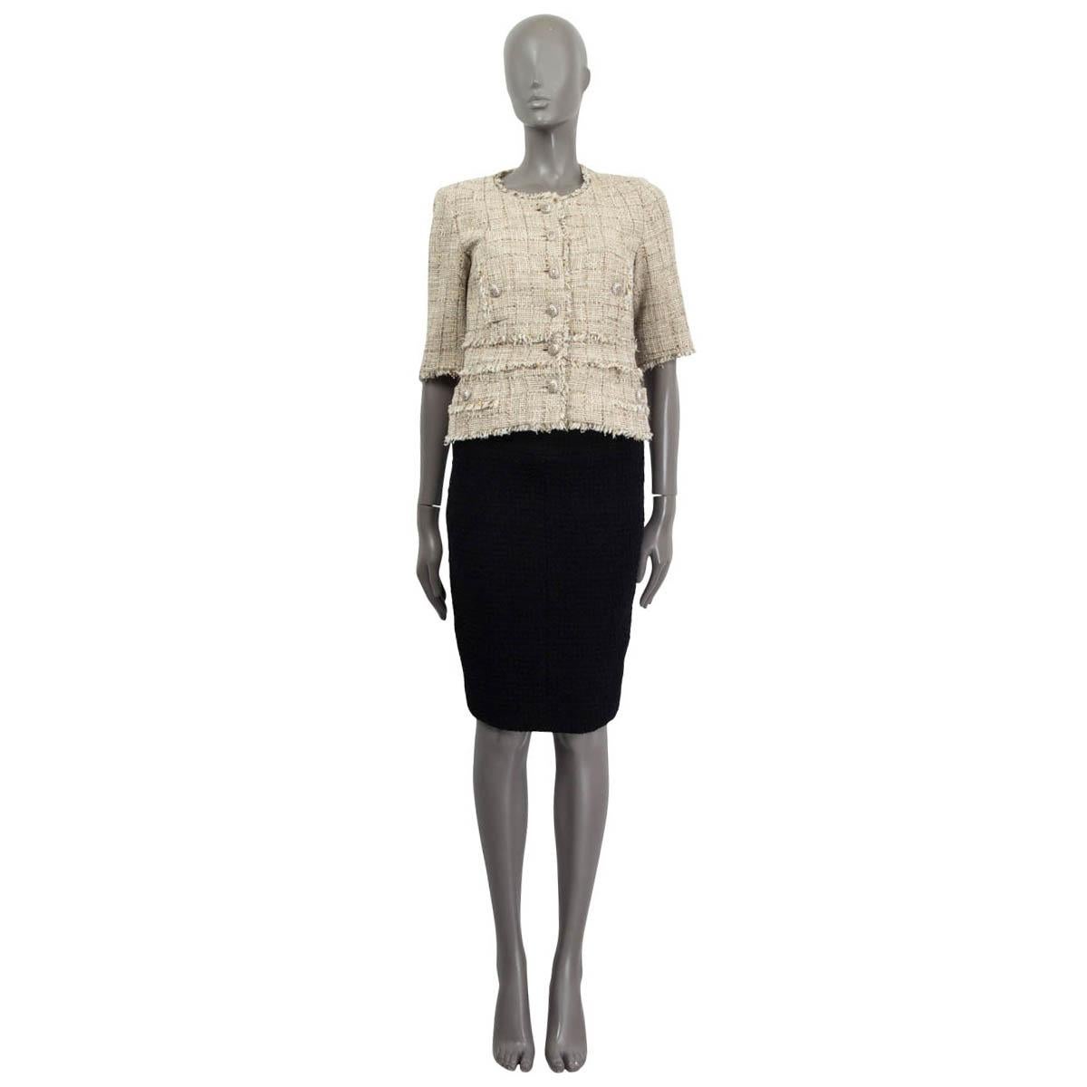 100% authentic Chanel tweed 3/4 sleeve jacket in beige, ecru, white, gold and silver cotton (52%), acrylic (21%), polyester (13%), rayon (6%), nylon (4%) and wool (4%). Embellished with small fringes around the neck, the hemline, buttoned pockets