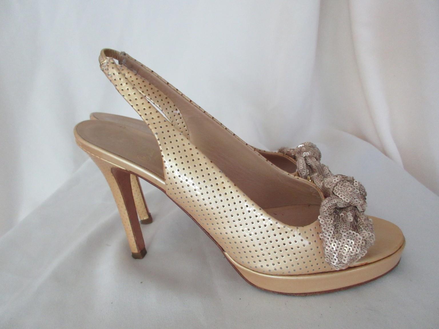 Ces magnifiques escarpins Chanel vintage en cuir verni beige et or sont ornés de nœuds en sequins dorés.

Nous proposons d'autres articles exclusifs, consultez notre boutique en ligne.

Détails :
Taille du talon 11 cm/ 4.33  pouce 
avec nœuds en