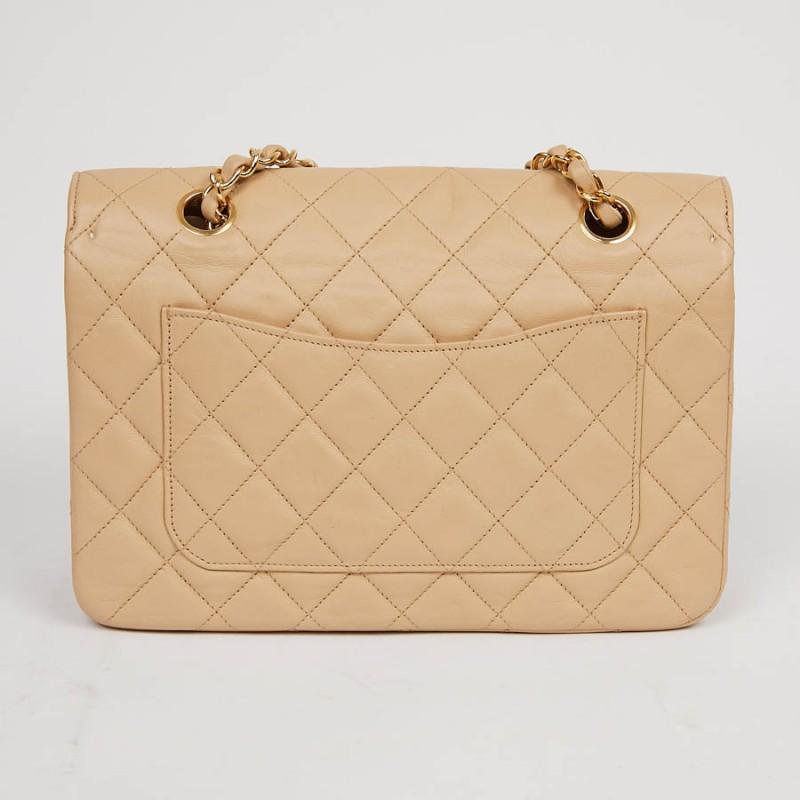 A great classic from Maison Chanel in beige quilted lambskin. The hardware is in gilded metal. 