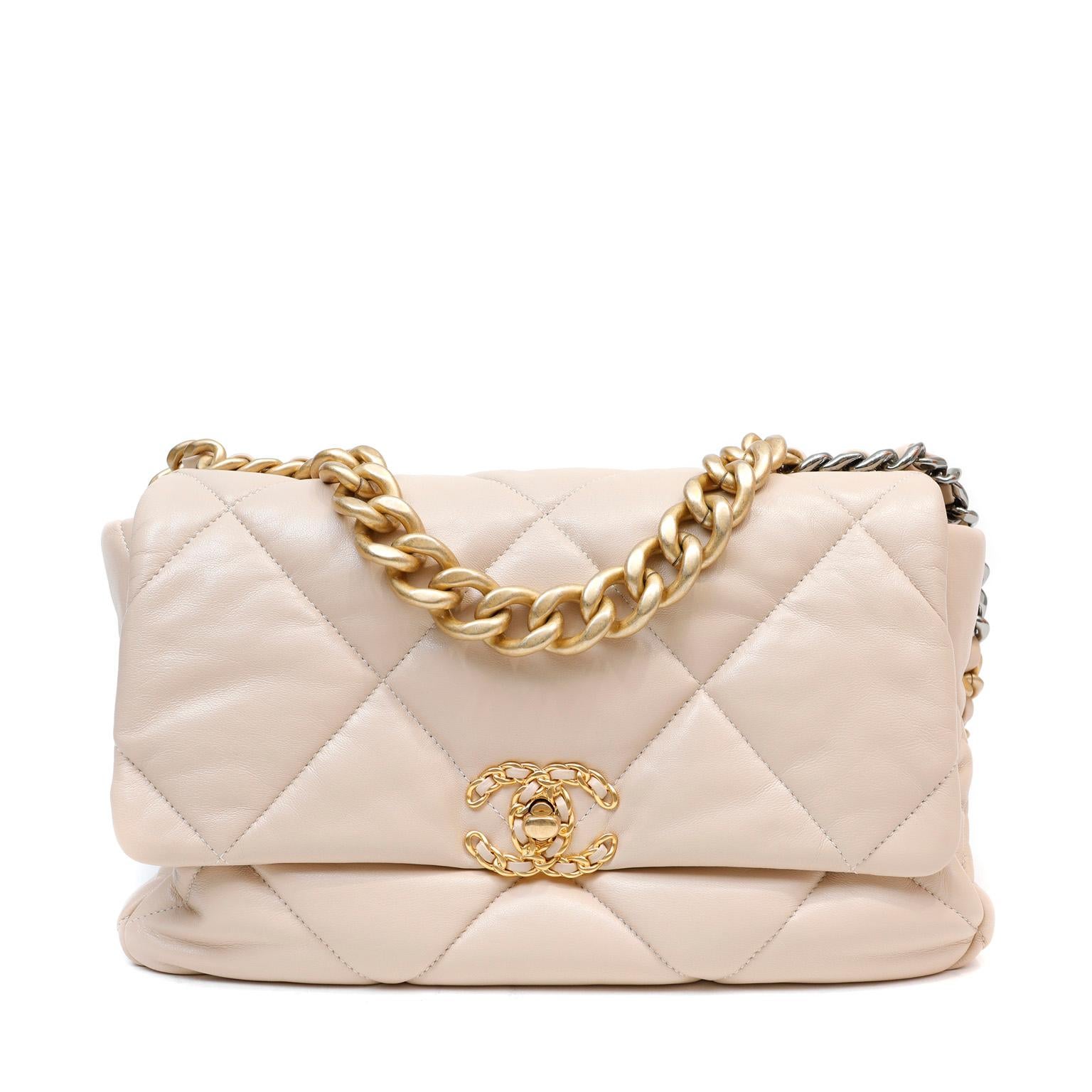 This authentic Chanel Beige Lambskin 19 Bag is in pristine unworn condition.  Released in 2019, the pillowy soft oversized quilts and mixed metals are a beautiful addition to the classic flap family.  Neutral beige lambskin is quilted in signature