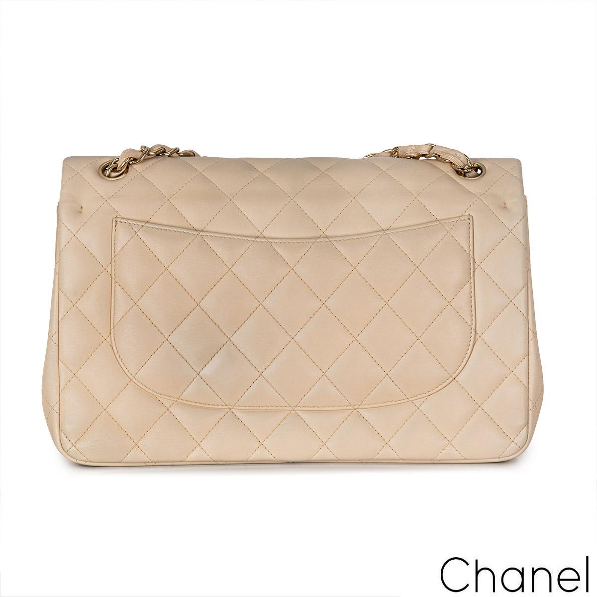 A gorgeous Chanel Jumbo Classic Double Flap Handbag. The exterior of this jumbo classic is in beige lambskin quilted leather with gold-tone hardware. It features a front flap with signature CC turnlock closure, half moon back pocket, and an