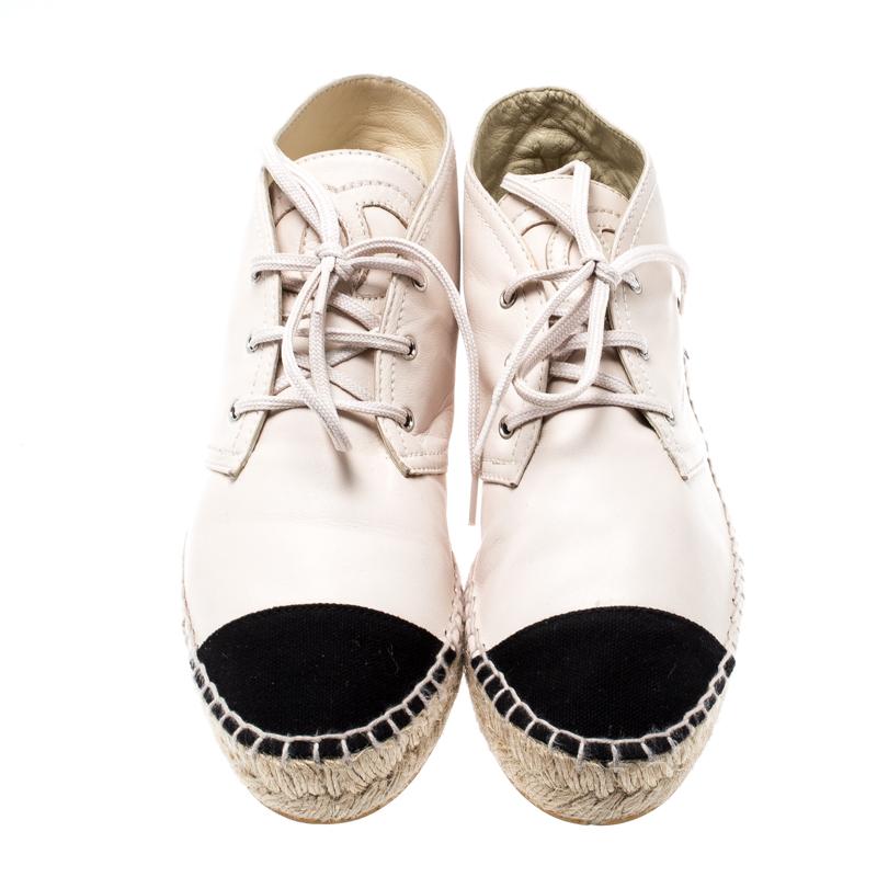 These Chanel sneakers are comfortable and stylish. Crafted from beige leather with black canvas cap toes, there is nothing you cannot pair these espadrilles with. They feature the signature CC logo on their tongues and have Chanel labelled insoles.