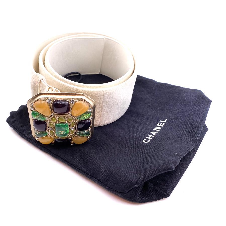 The belt is a piece from Maison CHANEL. A large beige leather tongue with a square of multicolored cabochons at the buckle, which gives it a very couture look.
The belt is in a very good condition. We perceive that it has already been used with