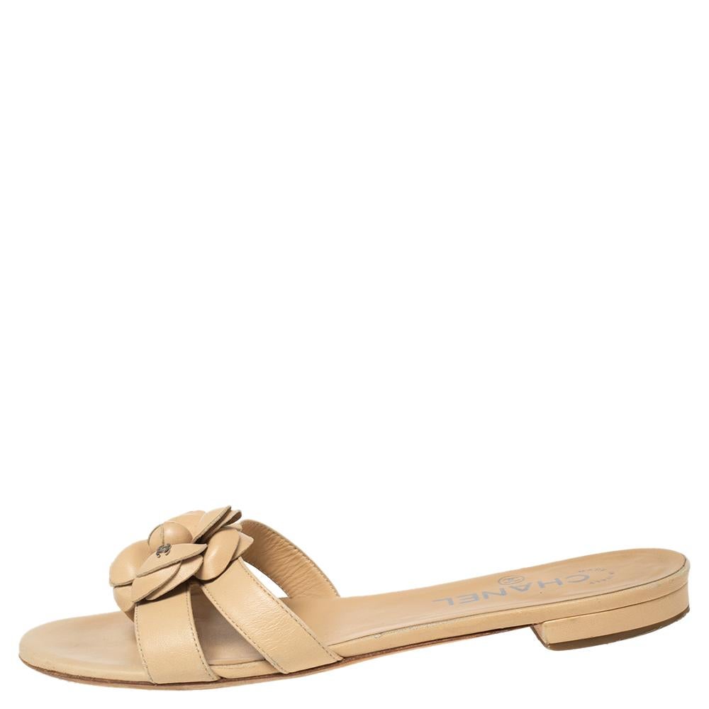 Chanel brings to you this pretty pair of Camellia flat slides in a beige color. Created from leather, these flats have leather flowers on the top of the straps and silver-tone hardware. The right choice to complete your summer outfit!