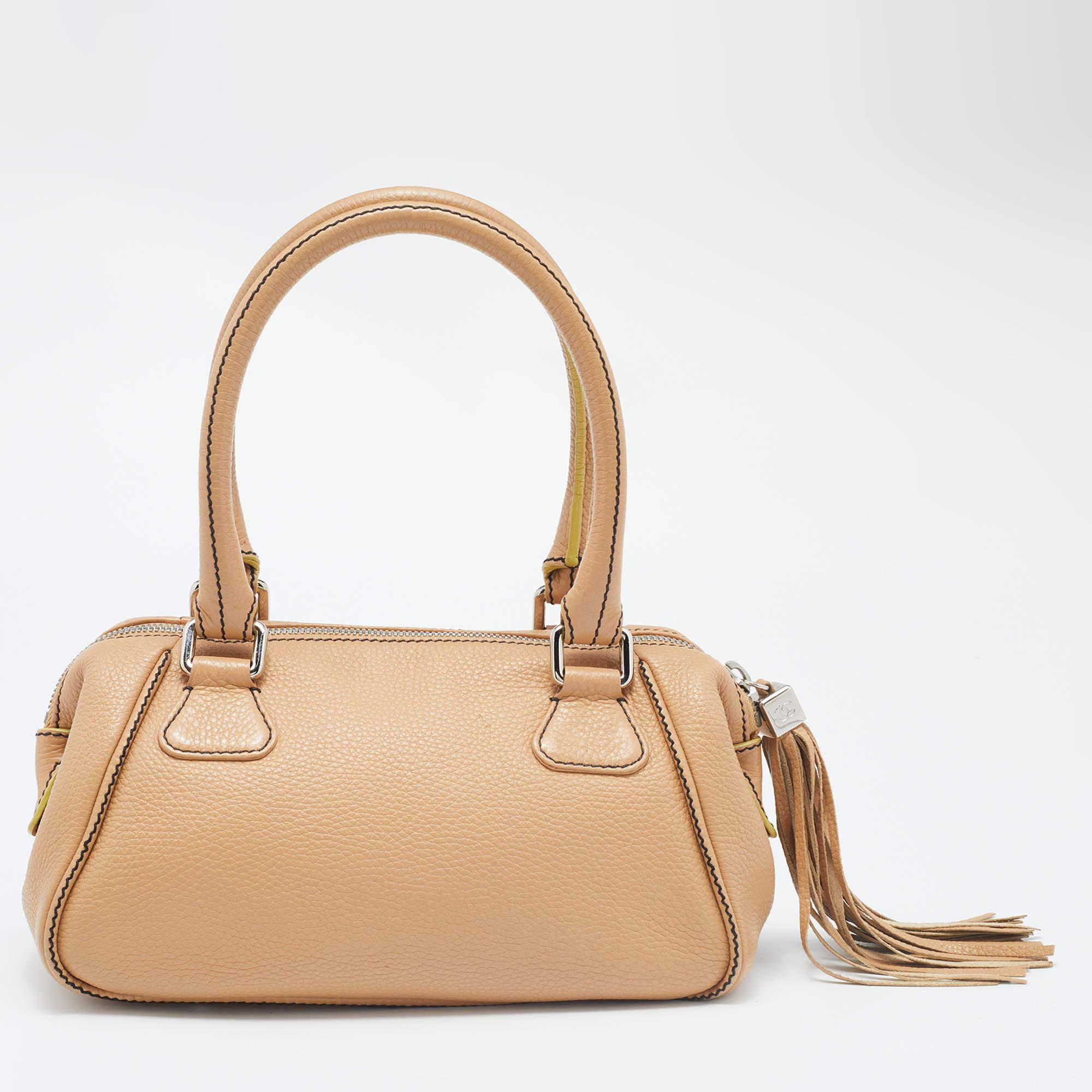 This Chanel bag reflects the magnificent designs and refined construction of the brand. Made from leather, the top zipper closure is equipped with a tassel, and it can be carried in a chic way with the dual handles. The fabric-lined interior of the