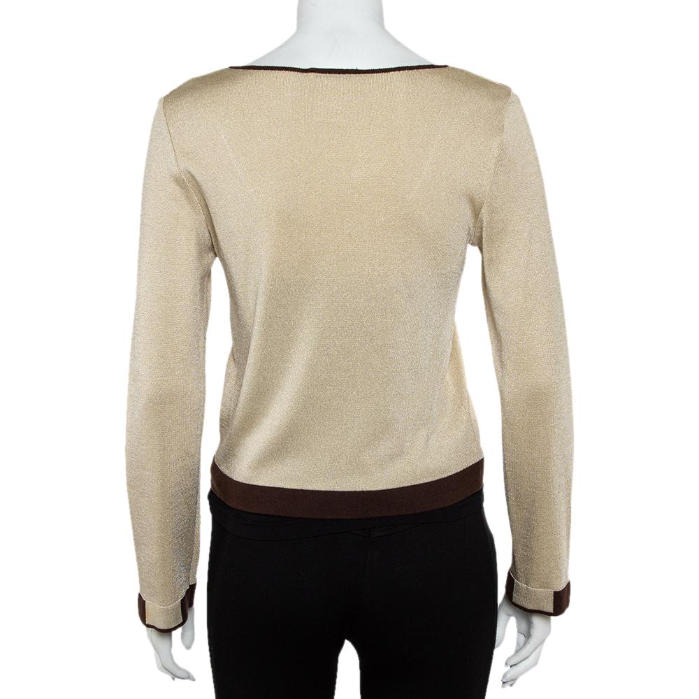 A blend of comfort and style, this Chanel lurex knit creation is exactly what one needs in a top. This cropped beige top features a wide, round neckline, long sleeves, and contrasting trims. You can pair the top with pants as well as skirts.


