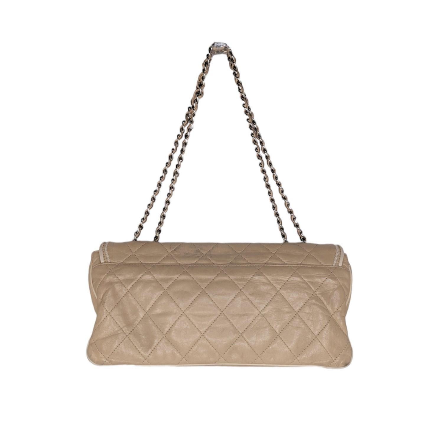 Go glam with this gorgeous Chanel Mademoiselle East-West Flap, crafted in beige diamond-quilted lambskin leather with contrast stitching, featuring a silver-tone chain link shoulder strap threaded with leather, sides that expand, a Mademoiselle