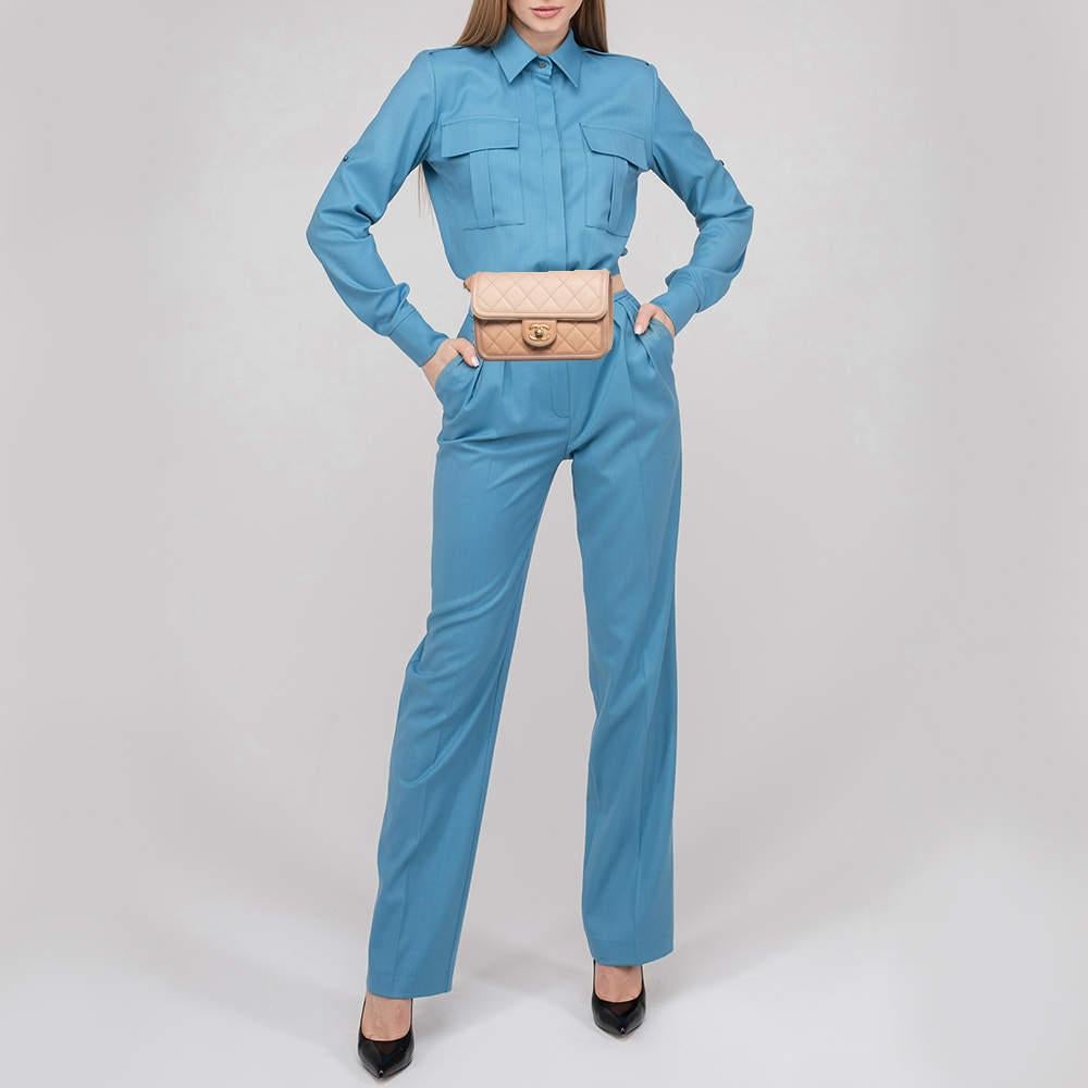 This belt bag from Chanel is indeed functional yet fashionable. It is crafted from quilted leather and displays the CC logo on the front in gold tone. It is completed with a front flap that reveals a well-sized interior. Wear it over jumpsuits for