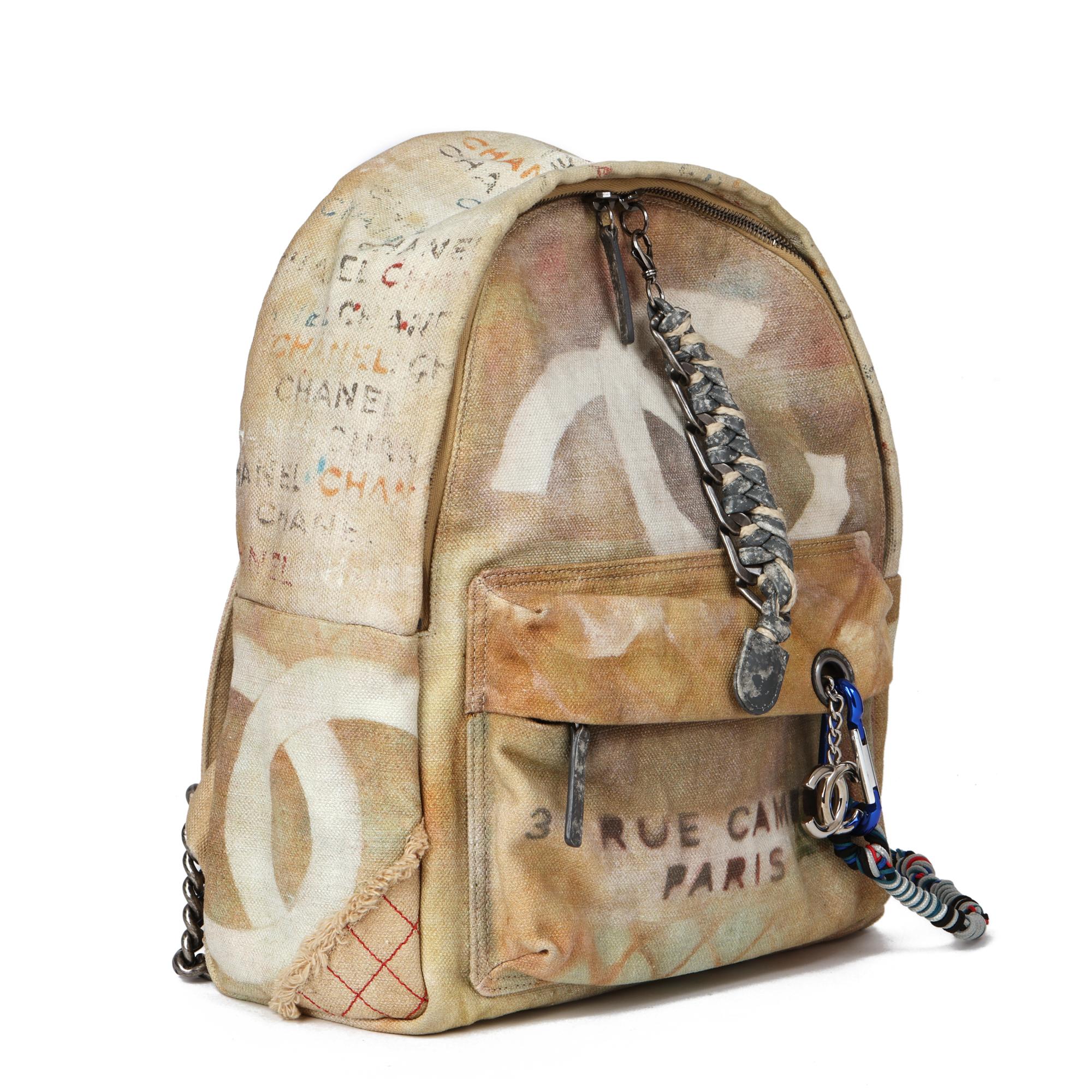 CHANEL 
Beige Painted Canvas Medium Graffiti Backpack

Xupes Reference: HB4552
Serial Number: 19445572
Age (Circa): 2014
Accompanied By: Chanel Dust Bag, Luggage Tag
Authenticity Details: Serial Sticker (Made in Italy)
Gender: Unisex
Type: