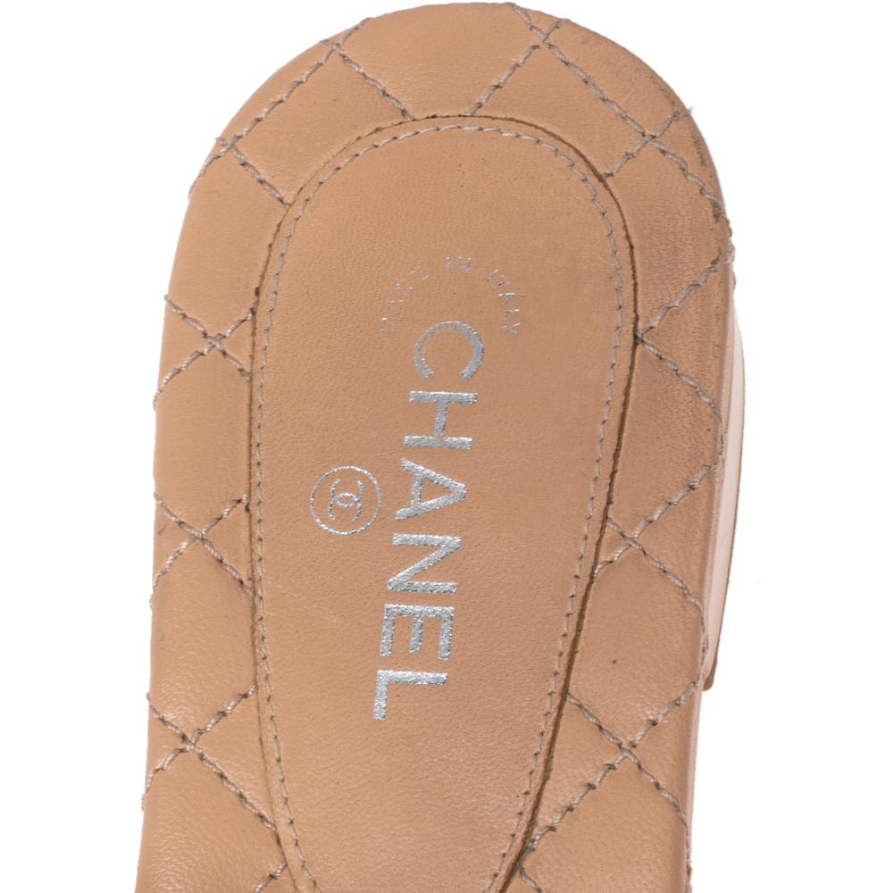 This summer, give the Chanel touch to your outfit with these lovely beige sandals. The pair features a thong design in patent leather straps along with comfortable leather soles. The flats are complete with the signature Camellia flowers on the