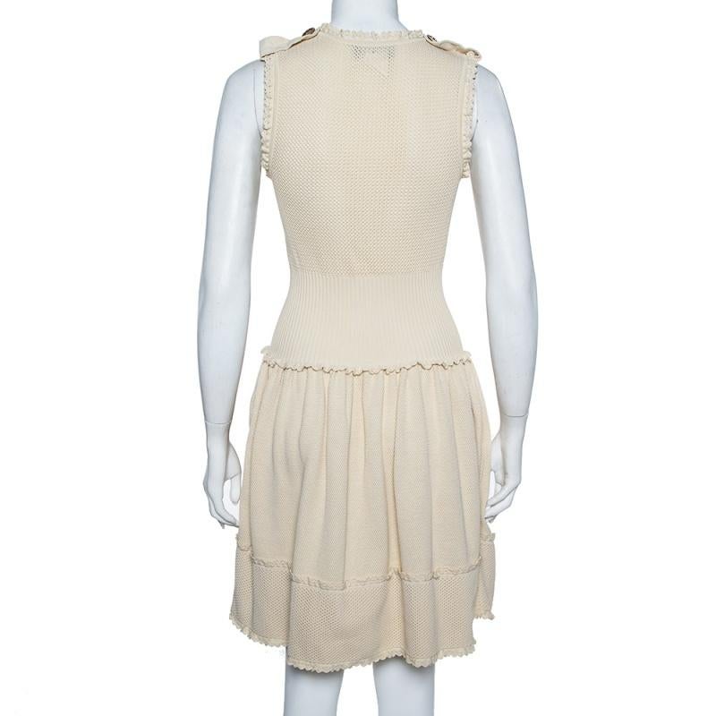 This dress will add an understated appeal to your off-duty looks. Designed in a comfortable fit and flare silhouette, this Chanel dress is cut from cotton. It flaunts a subtle beige hue and is beautified with a perforated knit pattern. Complete with