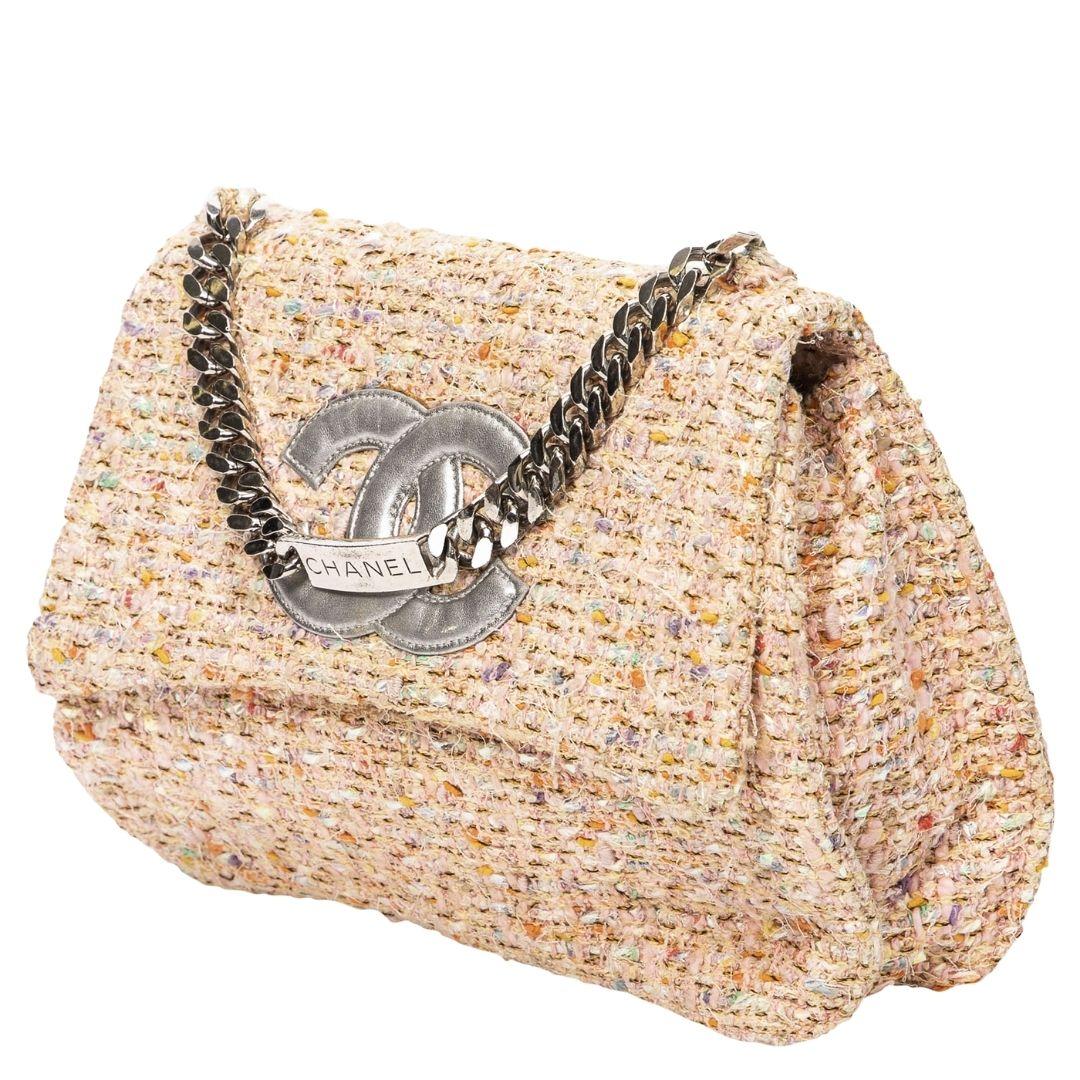 Chanel's beige/pink tweed bag, from the 1996 collection, dazzles with silver-tone hardware and a magnetic snap closure, unveiling a leather interior with a slip pocket.

SPECIFICS
Length: 9.8
