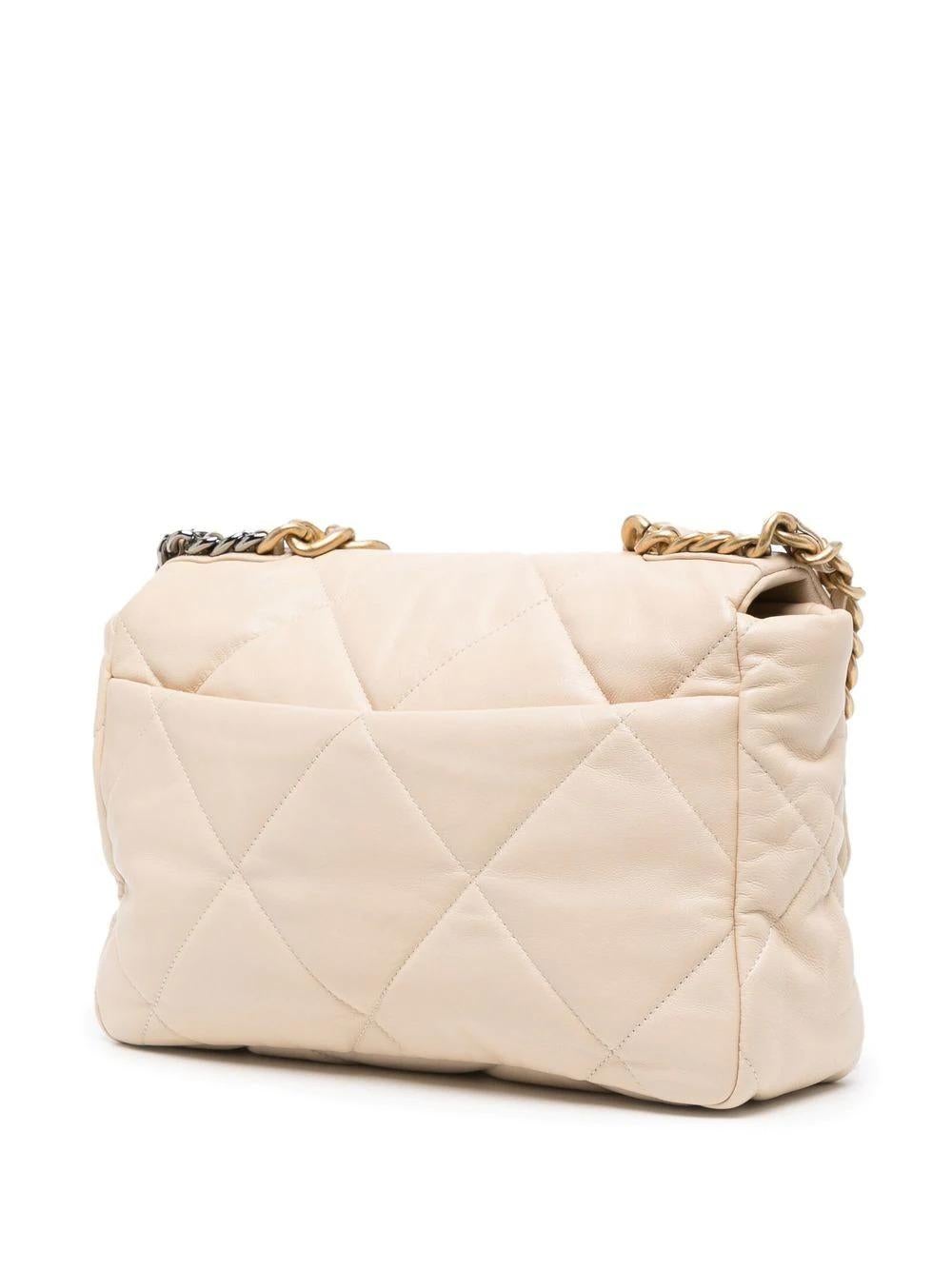 Crafted from beige lambskin leather, this pre-owned Chanel 19 has been designed in a padded, rectangular silhouette with the Maison's signature diamond quilting. Topped with the style chunky two-tone metal main and interwoven CC logo, this Large