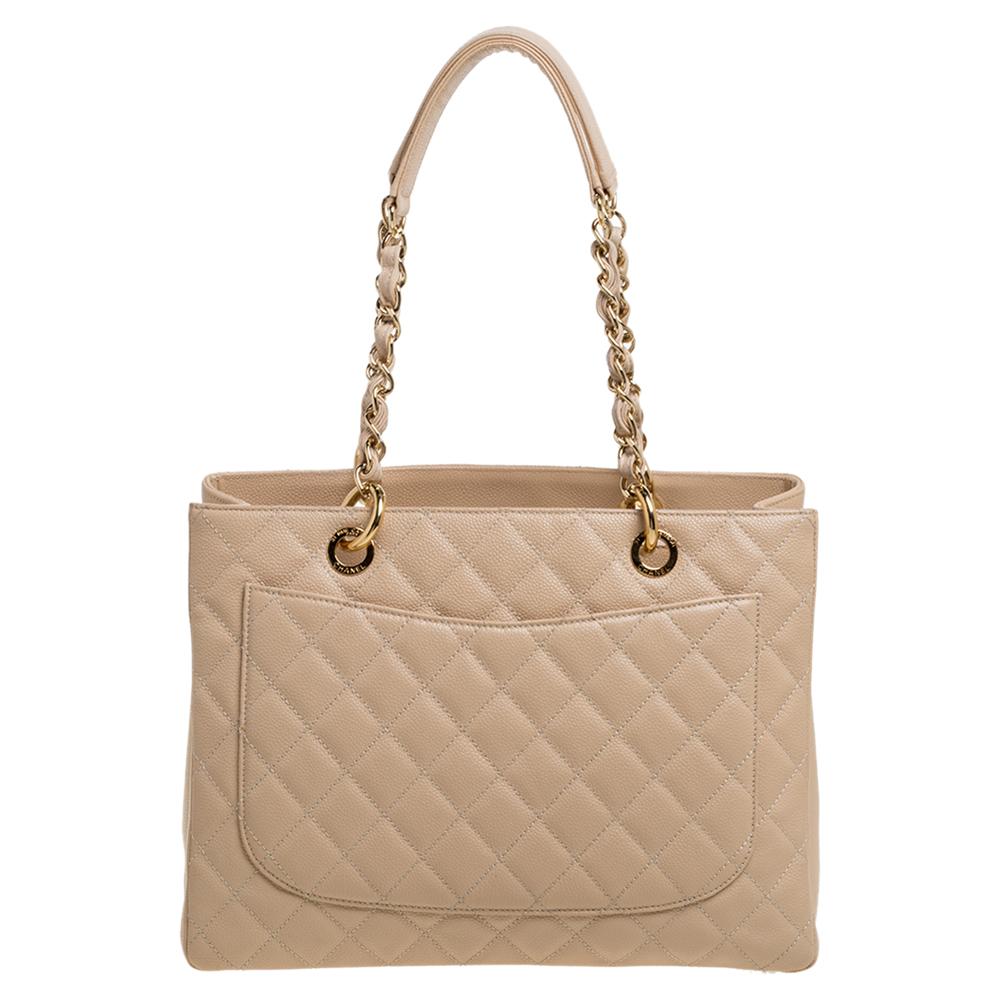Featuring top handles with chain trims and the CC logo on a quilted pattern, this Chanel Beige Caviar Leather Grand Shopping Tote exudes just the right amount of luxury. The bag features a spacious satin compartment divided by a zipper. It has an
