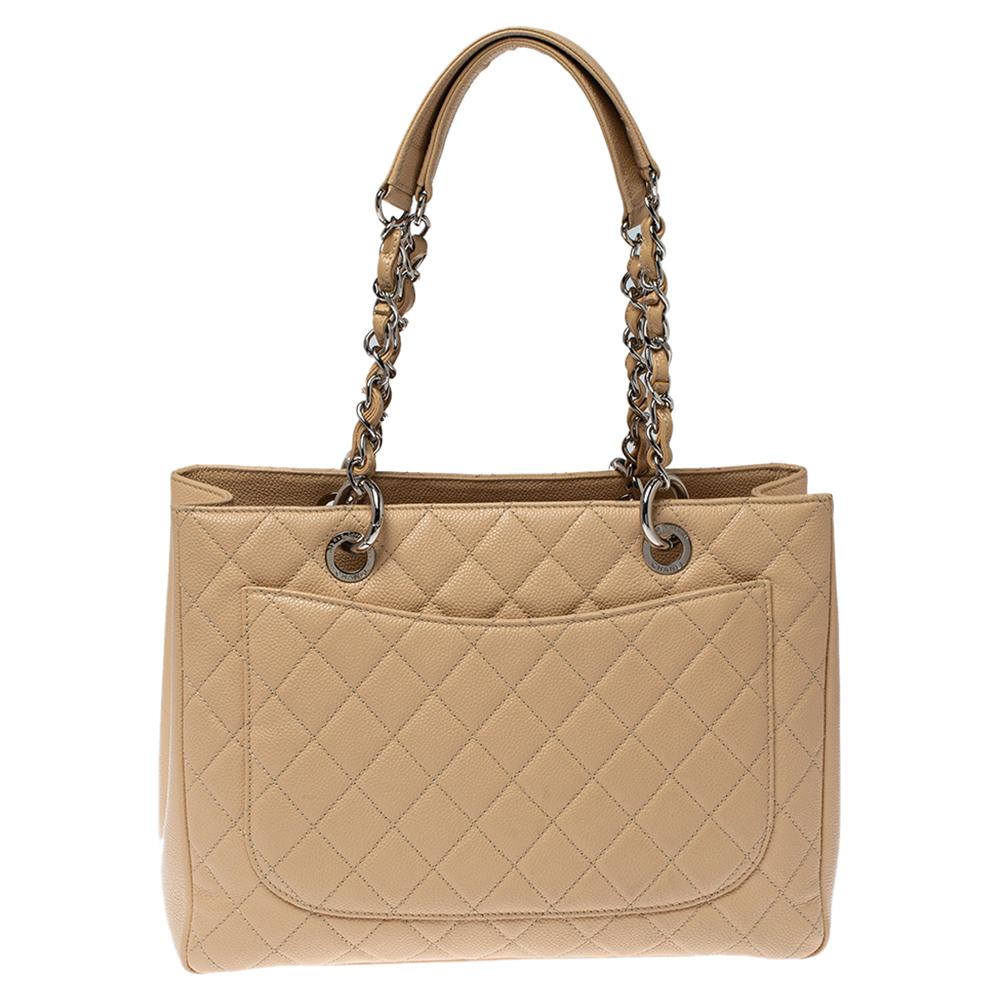 Featuring top handles with chain trim and the CC logo on a quilted pattern, this Chanel beige Caviar leather tote exudes just the right amount of sophistication. The bag features an open-top, with a spacious compartment divided by a zipper. It has