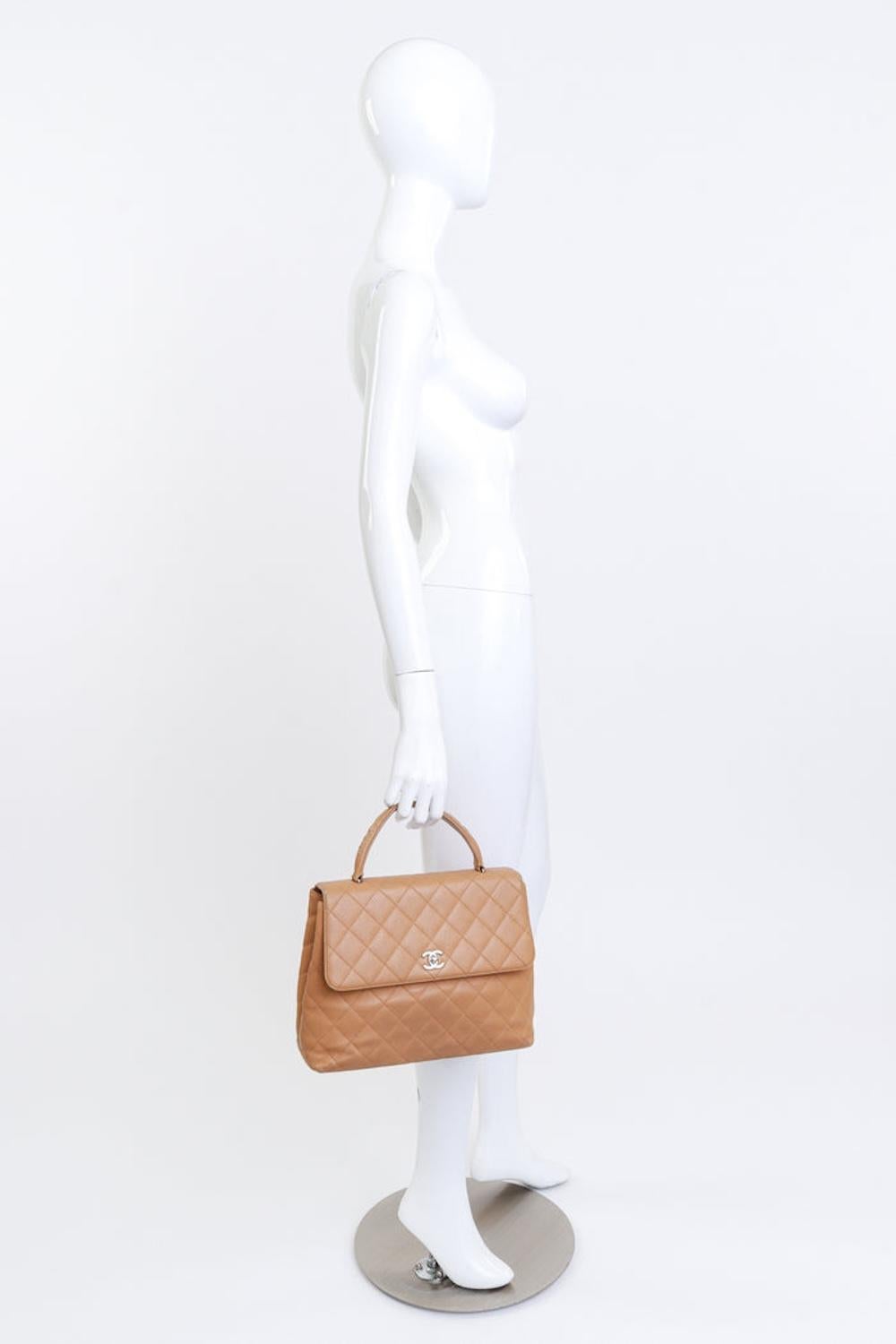 This vintage Kelly handbag is inspired by the Sac à Dépêches, originally designed by Hermès in the 1930s and later popularized by Grace Kelly in the 1950s. Chanel has since created its own reproductions of this timeless silhouette. Made from beige