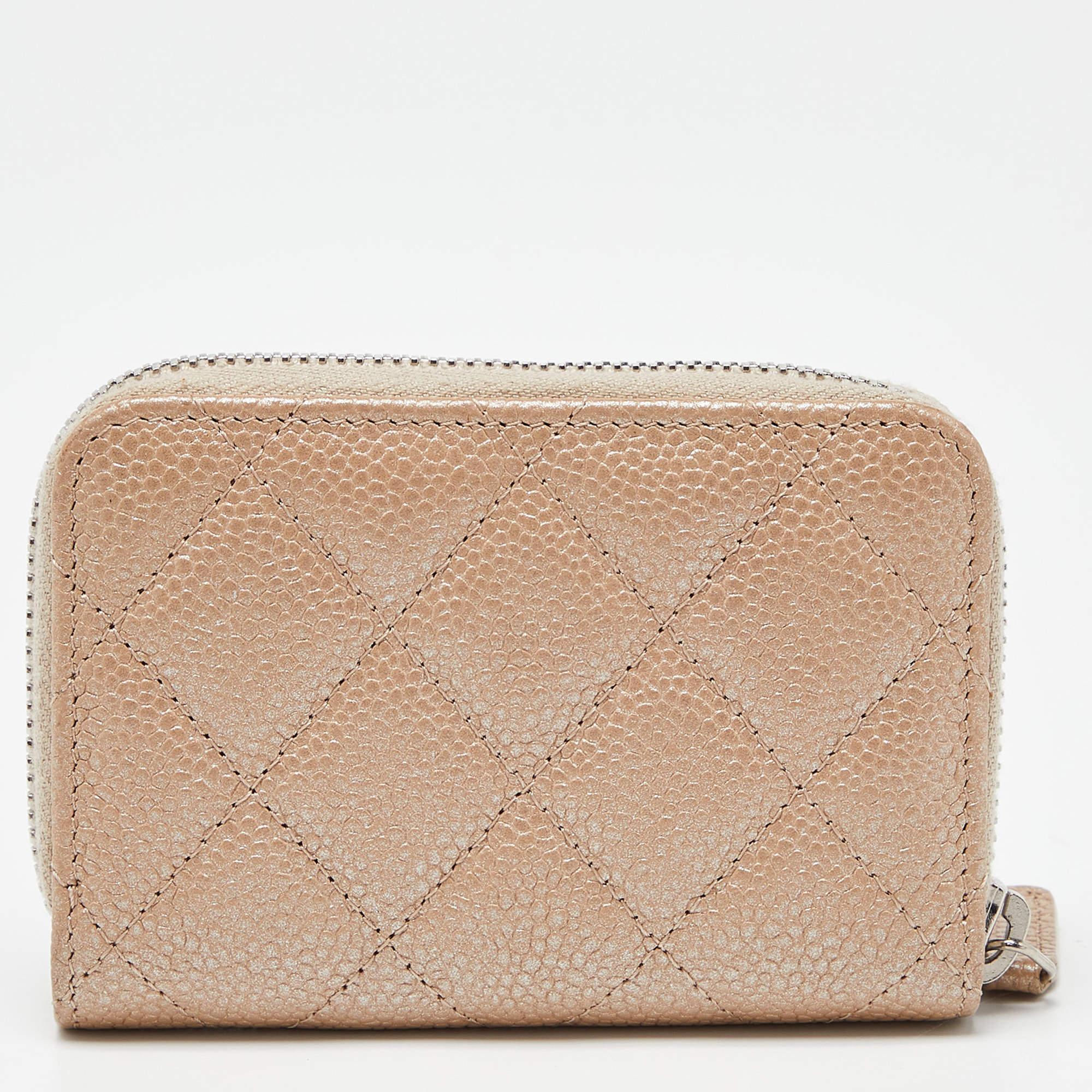 This Chanel coin purse is conveniently designed for everyday use. Crafted from beige Caviar leather, it has a zip closure that opens to reveal lined compartments and slots for you to neatly arrange your things.

Includes: Original Dustbag, Original