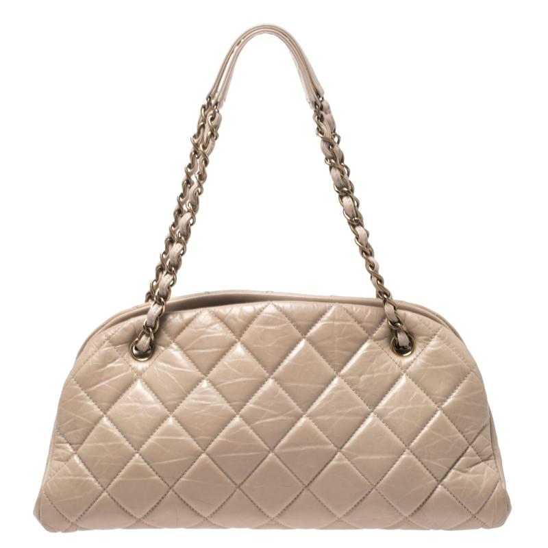 Spacious and captivating, this Just Mademoiselle Bowling bag is from Chanel. It has been crafted from beige crackled leather and features the iconic quilted pattern. It is equipped with two chain handles and a well-sized fabric interior to keep your