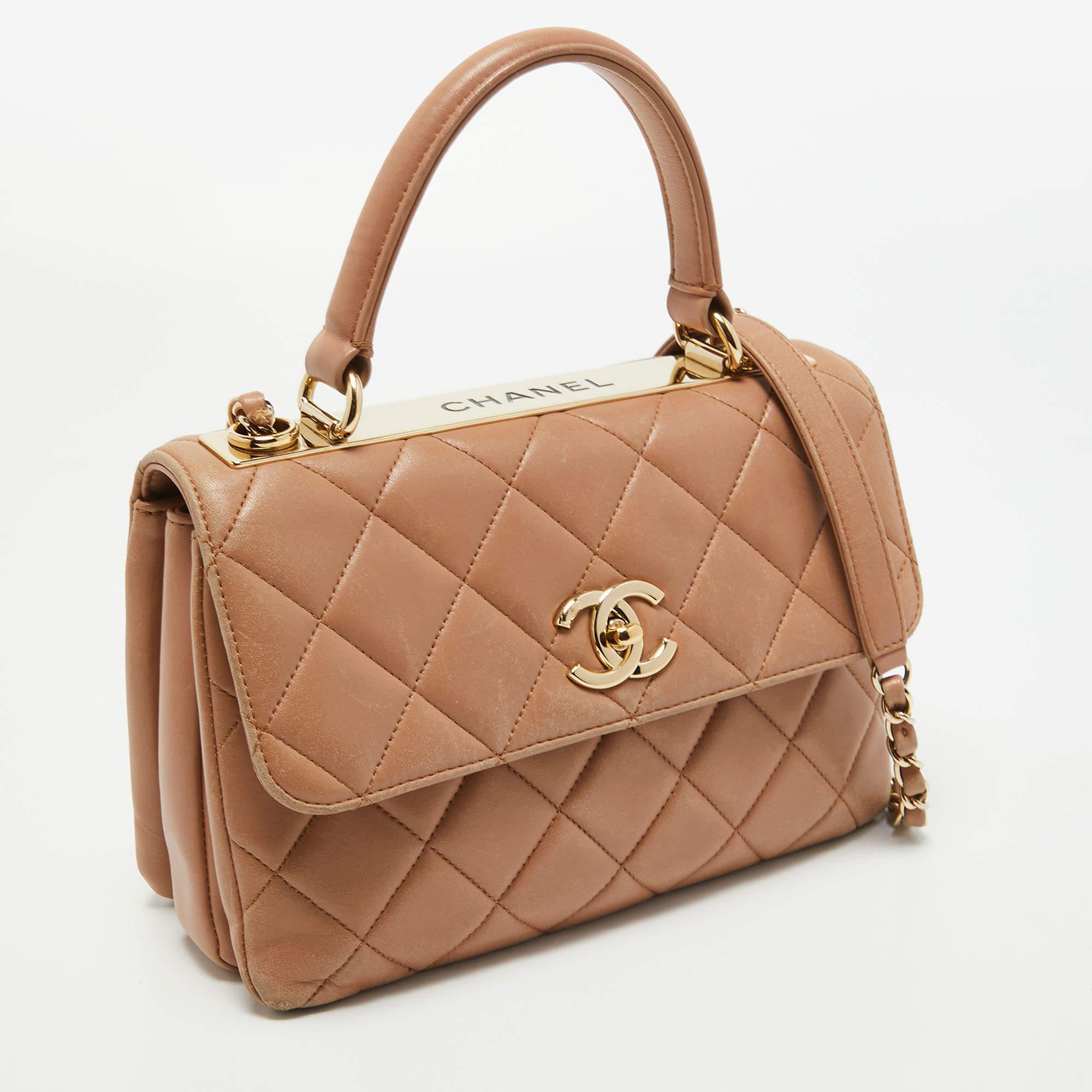 Diese trendige CC Flap Tasche aus dem Hause Chanel wird Ihrer Garderobe sicherlich einen Hauch von Luxus verleihen. Die mit dem kultigen CC-Schloss auf der Vorderseite verzierte Tasche ist aus beigefarbenem, gestepptem Leder gefertigt und hat eine