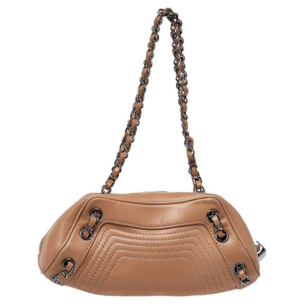 This impressive bag is from the house of Chanel. Crafted from leather, this stylish creation features a beige hue. The creation comes with a tassel-detailed zip closure and dual handles so you can swing it in style. The bag is finished with the