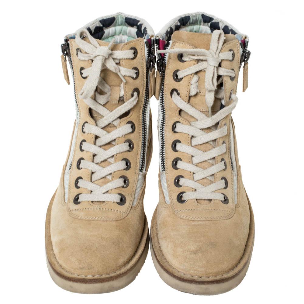 Flaunt your love for the latest trends with these combat boots from Chanel. Built to last and add sophistication to any outfit, these beige-hued combat boots are all you need. They are crafted from quality suede and canvas. They are styled with