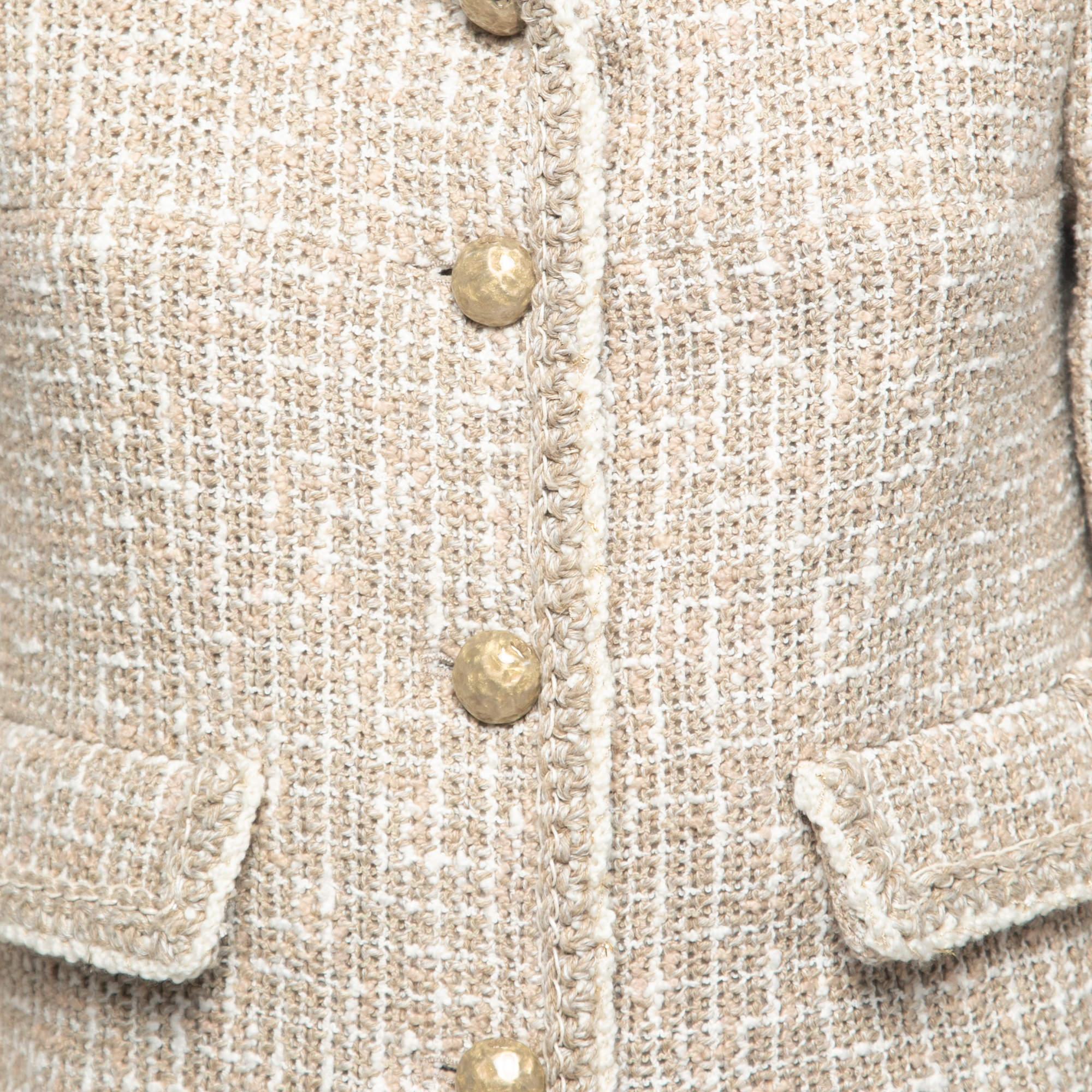 The Chanel jacket is a timeless fashion piece that exudes elegance and sophistication. Crafted from high-quality beige tweed fabric, it features a cropped silhouette that complements various outfits. The jacket is adorned with exquisite gold
