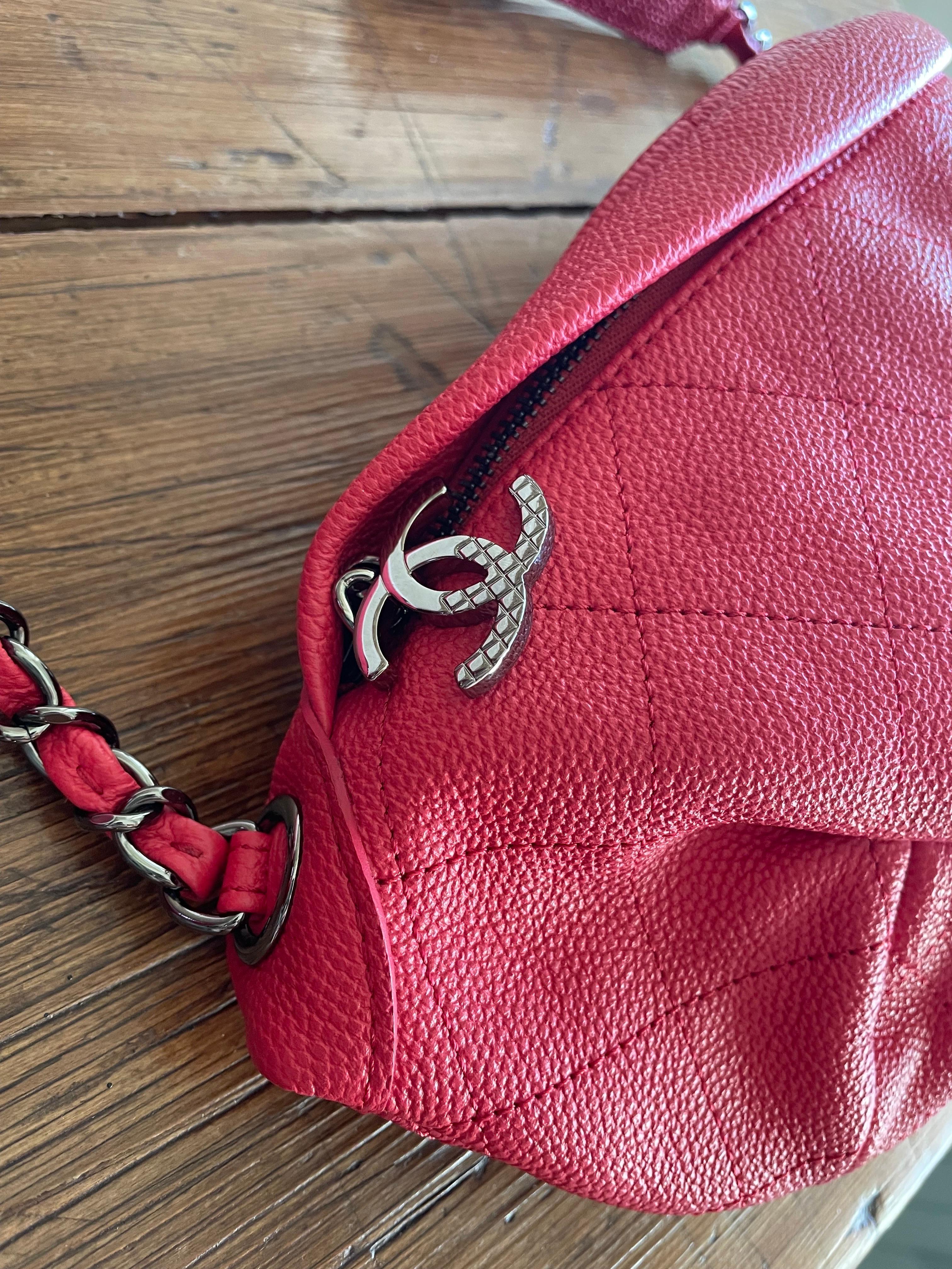 Coral red Chanel fanny pack with silver hardware. Zip closure and logo charm. Adjustable belt with part leather and part chain. Very soft and capacious. 30 cm wide, 18 cm high and 8 cm deep. In perfect condition with dust. 