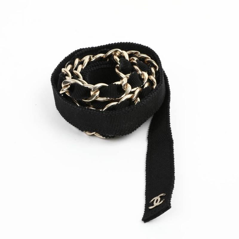 This CHANEL belt with gold chain is interwoven with a black fabric.
It is a recent belt, which reminded us those created by Karl Lagerfeld in the 80's.
It can be worn over any outfit. 
It has never been worn.
Presence of the stamp (year 2020), it