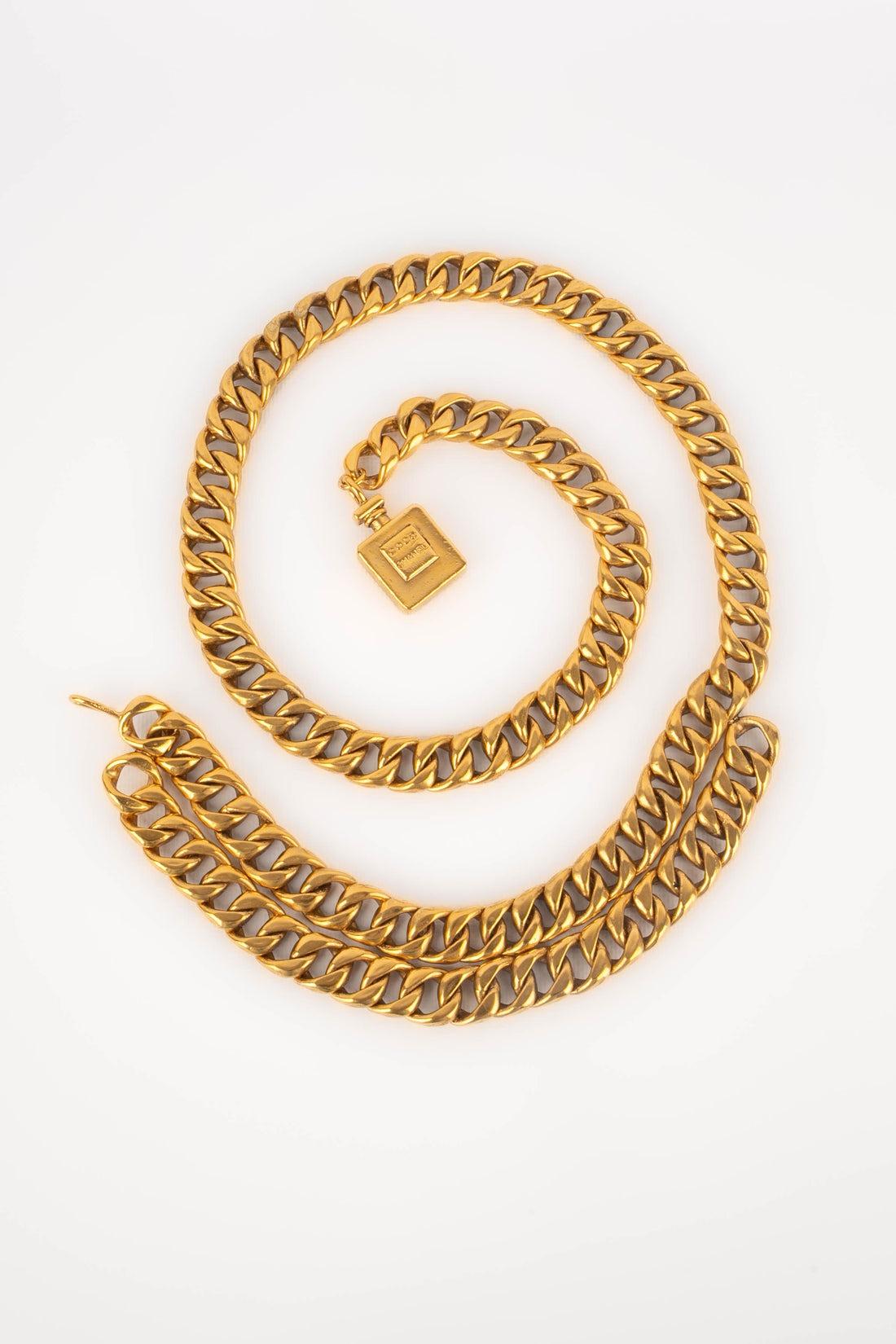 Chanel - (Made in France) Golden metal belt with wide links and a pendant representing a bottle of perfume. Engraved signature on the belt hook. 1988 Circa.

Additional information:
Condition: Very good condition
Dimensions: Length: 100 cm
Period: