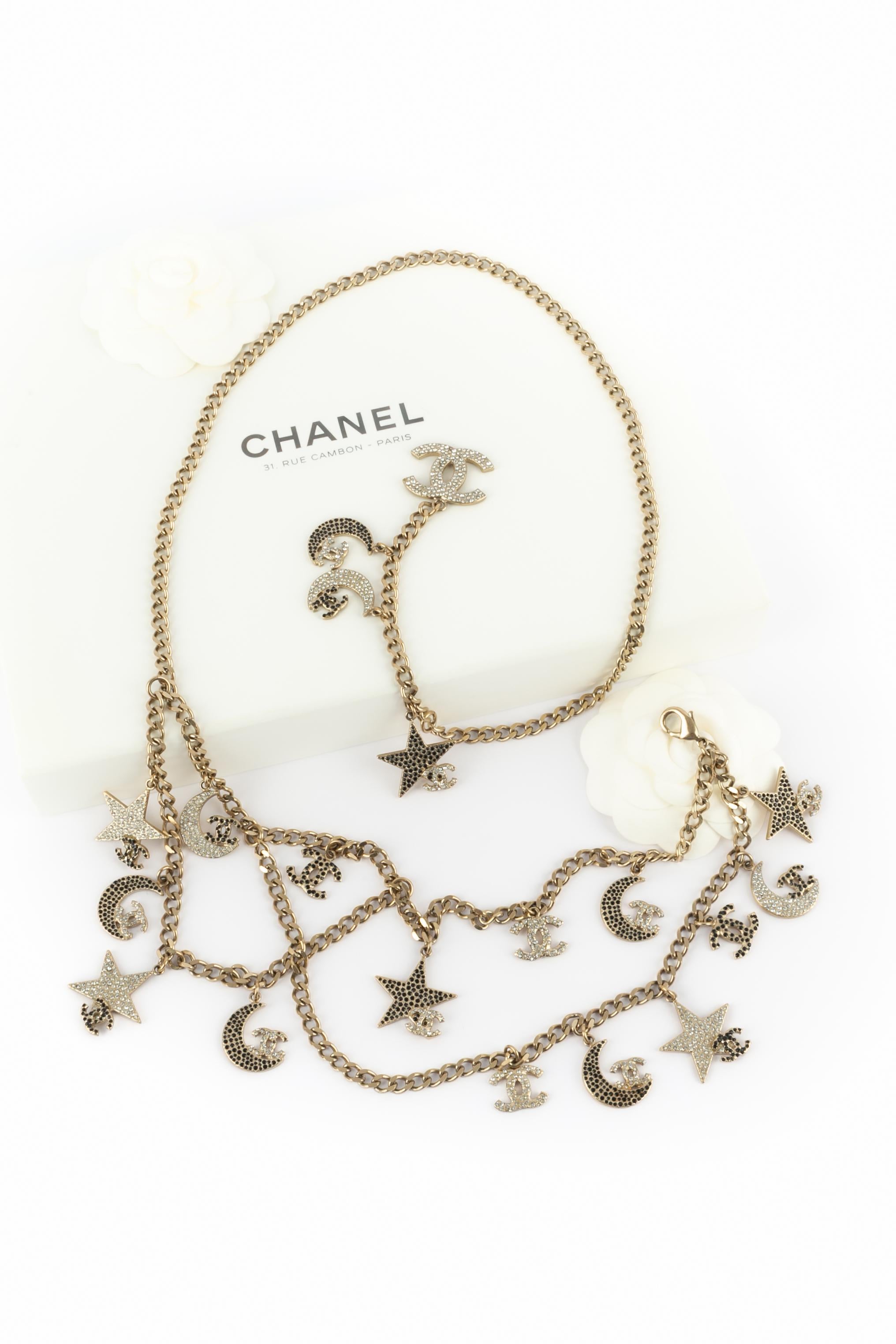 CHANEL - (Made in France) Champagnerfarbener Metallgürtel, verziert mit mehreren strassbesetzten Charms, die Monde, Sterne und cc-Logos darstellen. Spring-Summer Collection'S 2008 unter der künstlerischen Leitung von Karl Lagerfeld.

Bedingung:
Sehr