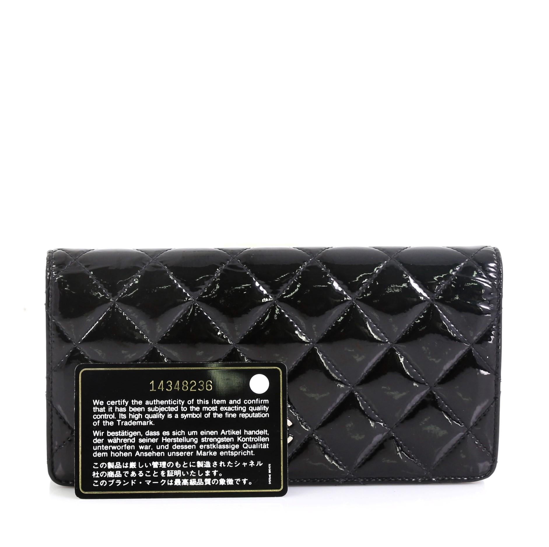 This Chanel Bi-Fold Wallet Quilted Patent, crafted from black patent leather, features Chanel's signature diamond quilted design textured CC logo at front and silver-tone hardware. It opens to a black leather interior with multiple card slots, zip