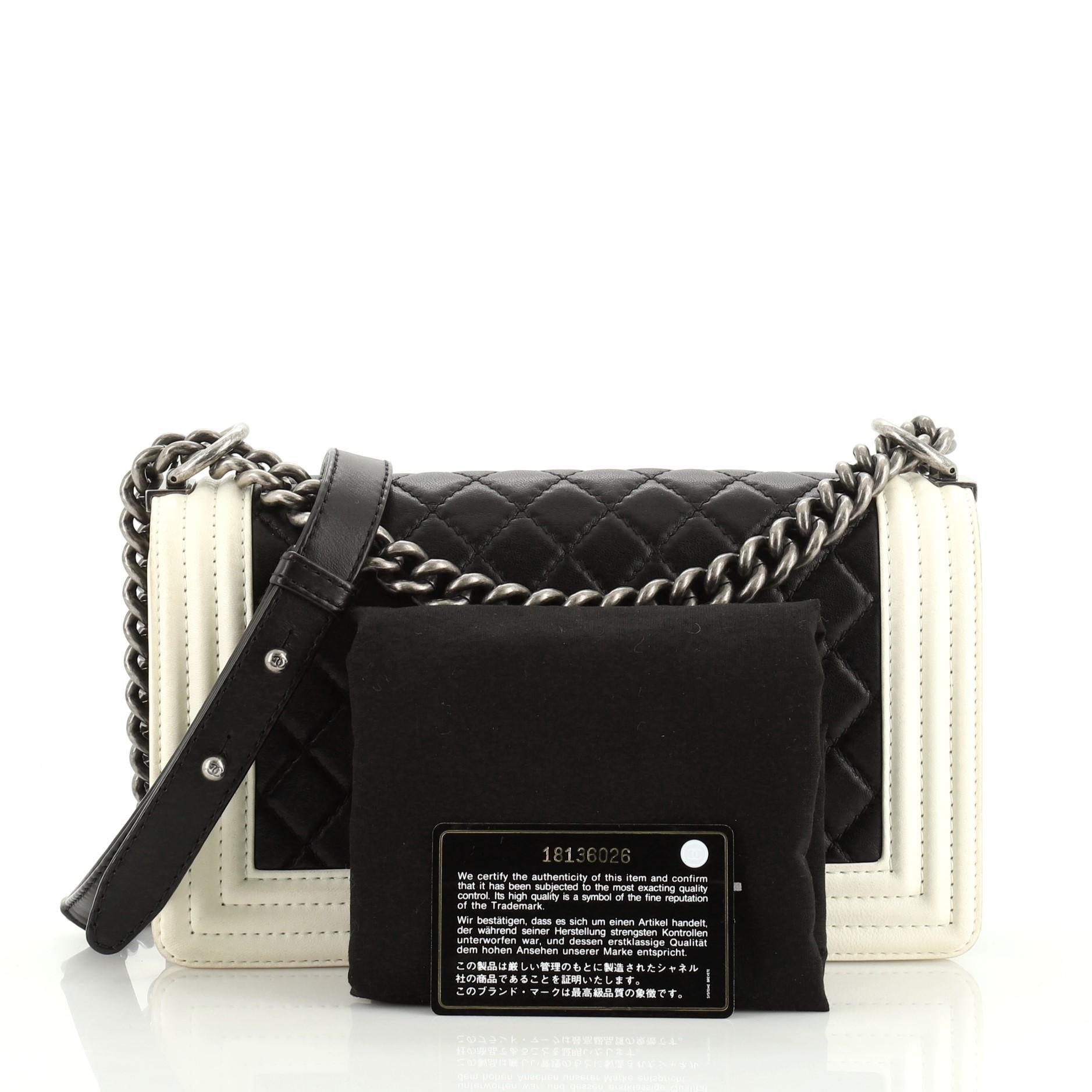 This Chanel Bicolor Boy Flap Bag Quilted Calfskin Old Medium, crafted from black calfskin leather, features chain link strap with adjustable leather strap and aged silver-tone hardware. Its CC boy push-lock closure opens to a white nylon interior