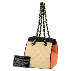 Sac panier Chanel en paille de raphia bicolore matelassé avec logo CC et chaîne 858721