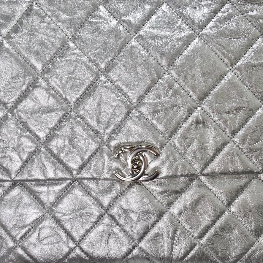 Ce sac métallique exquis de Chanel brille à la lumière ! Chanel présente une version modernisée de son sac à main emblématique avec ce cuir de veau argenté métallique froissé et piqué de diamants. Le cuir matelassé signé Chanel est orné de