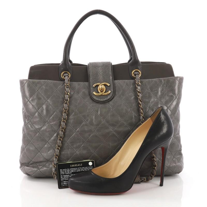 This Chanel Bindi Tote Quilted Leather with Stingray Large, crafted in gray quilted calfskin leather, features genuine stingray accents on the flap and drawstring loops, bijoux style chain straps with stingray leather pads, protective base studs,