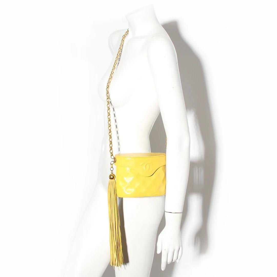 Chanel by Karl Lagerfeld Binocular Handbag 
From 1989 - 1991 
Made in Italy
Yellow Lambskin 
Quilt stitching detail 
Flap has interlocked CC detail on front flap closure 
Oversize yellow fringe detail on right side of bag
Fringe has spherical gold