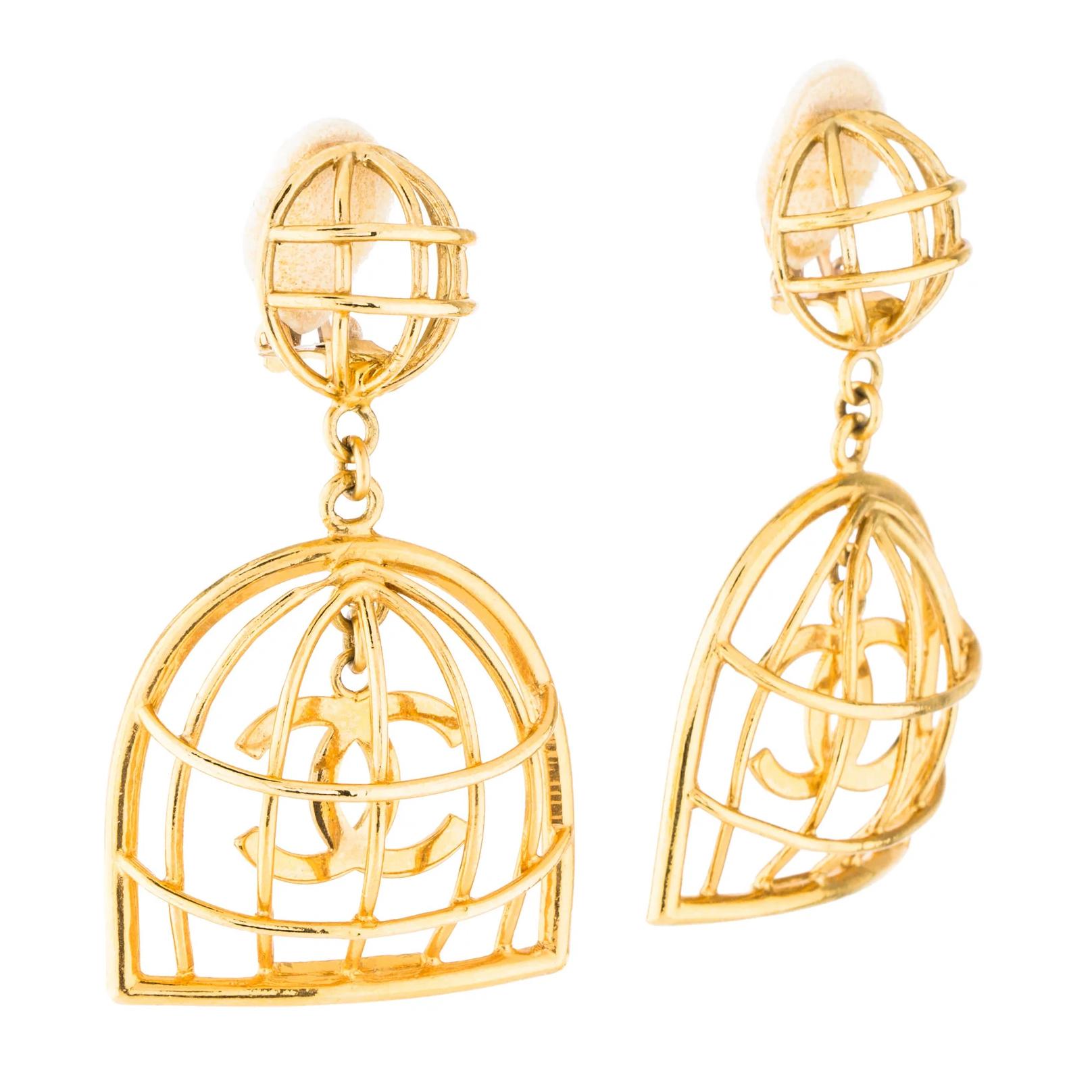 Gold-tone Chanel earrings featuring birdcage motif, CC logo, and clip-on closures. Collection 29.
Total Item Weight: 31.9g
Clasp Style: Clip-On

COLOR/MATERIAL: Gold tone metal
MEASURES: Drop 2.80” & Width 1.50”
COMES WITH: Box
CONDITION: Good -