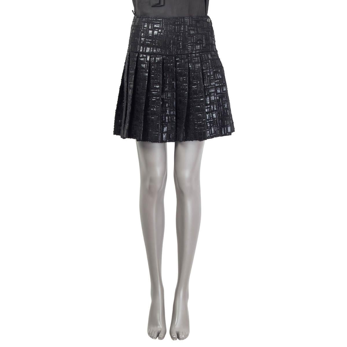 100% authentic Chanel Fall 2013 pleated textured a-line skirt in black acrylic (39%), nylon (29%), wool (26%), polyester (5%) and silk (1%). Features a small 'CC' emblem at front. Opens with a concealed zipper and a hook at the side. Lined in black