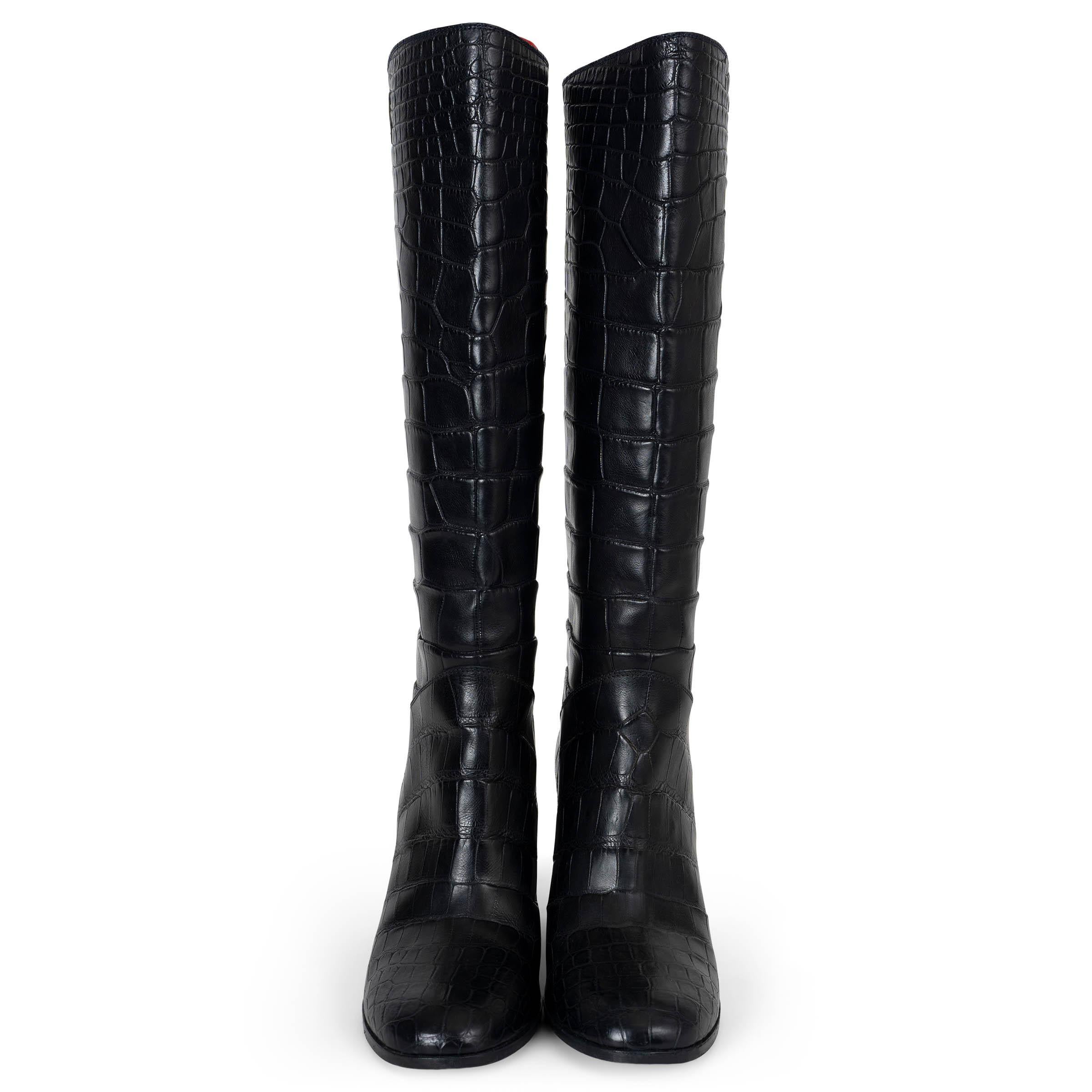 Diese 100% authentischen kniehohen Chanel Stiefel sind aus luxuriösem schwarzem Krokodilleder gefertigt und bieten einen kühnen und anspruchsvollen Look. Mit runder Schuhspitze, Pfennigabsatz und dem kultigen CC-Logo am Schaft verbinden diese