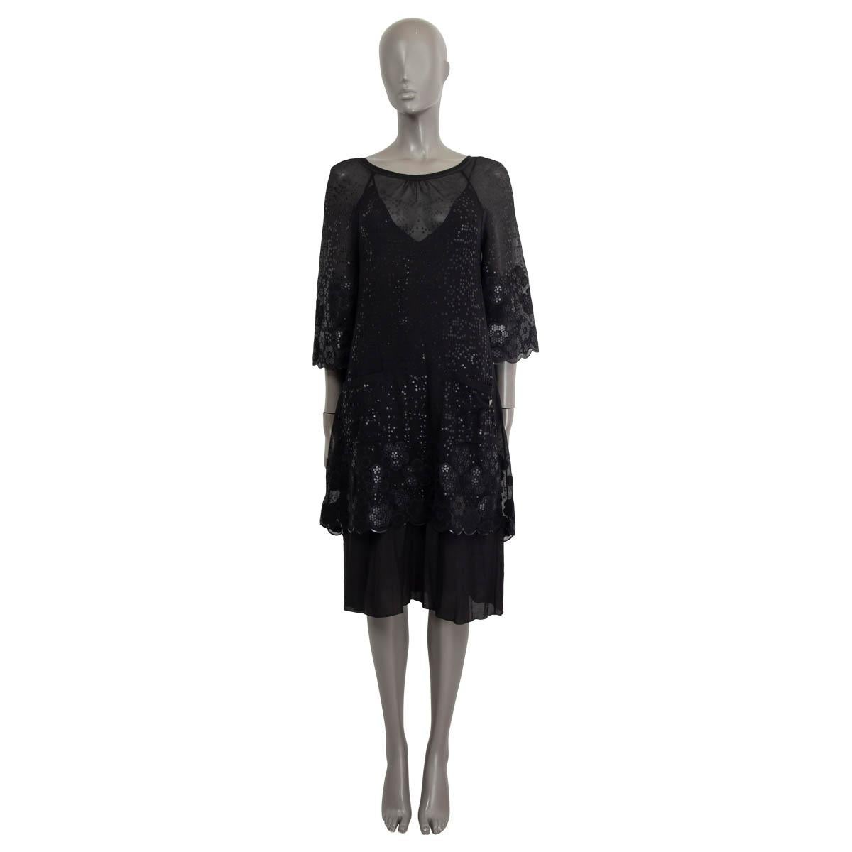 100% authentic Chanel sheer mini dress in black silk and polyamide (assumed cause tag is missing). Embellished with sequin camellias all over the dress. Features 7/8 raglan sleeves (sleeve measurements taken from the neck) and two patch pockets on