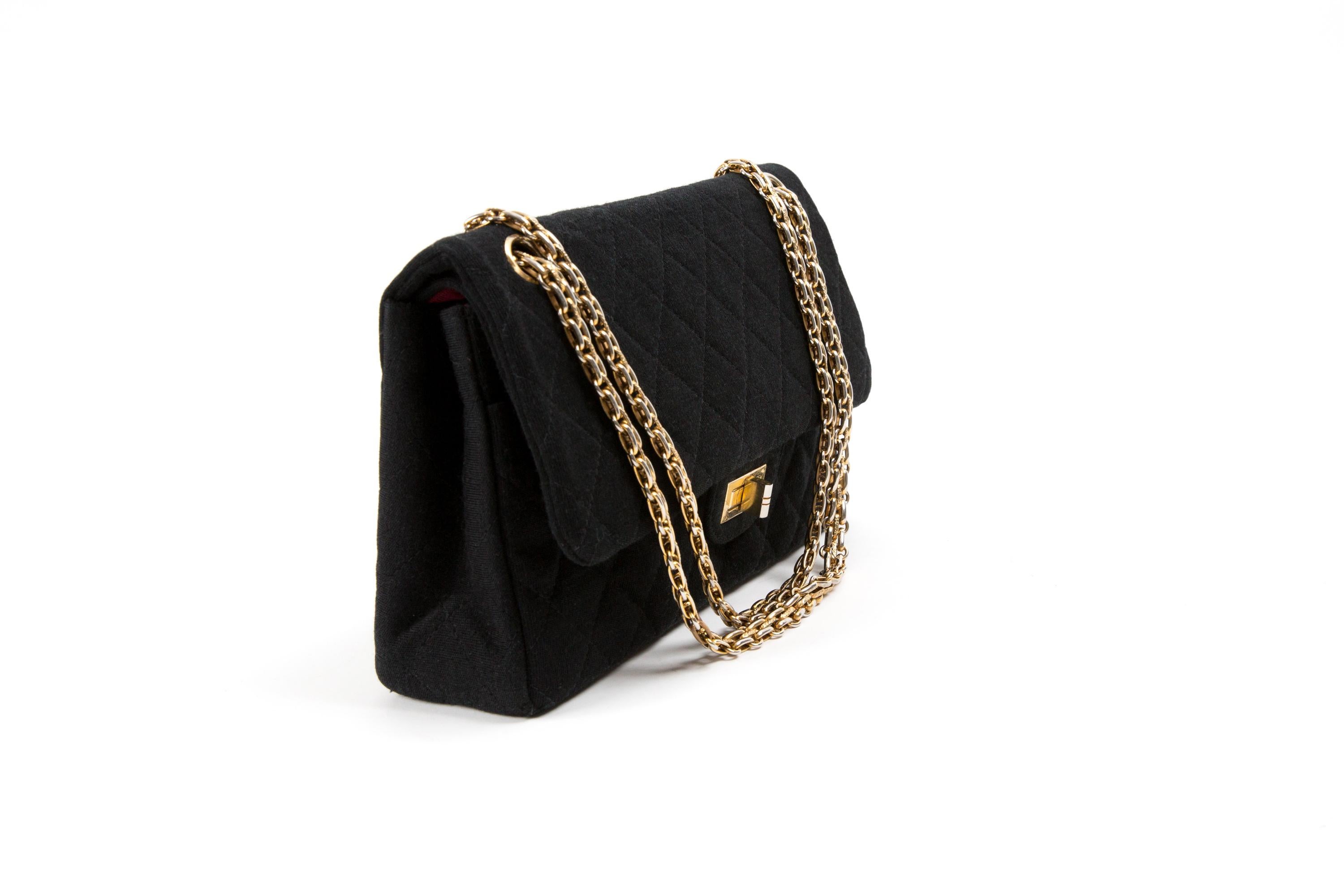 Chanel Black quilted jersey 2.55 shoulder bag featuring a double foldover top, a twist lock and a double chain shoulder strap (Shoulder: strap: 27.1in. (69cm)), a back patch pocket, gold tone hardware, a red silk ottoman lining, inside red silk